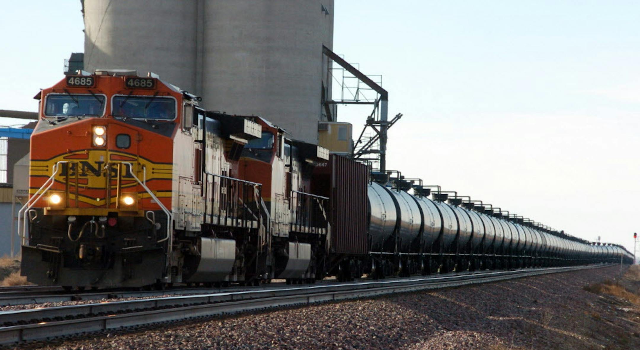 FILE - This Nov. 6, 2013, file photo shows a BNSF Railway train hauling crude oil near Wolf Point, Mont. Thousands of older rail tank cars that carry crude oil would be phased out within two years under regulations proposed in response to a series of fiery train crashes over the past year. Transportation Secretary Anthony Foxx said the government's testing of crude oil from the Bakken region of North Dakota and Montana shows the oil is on the high end of a range of volatility compared with other