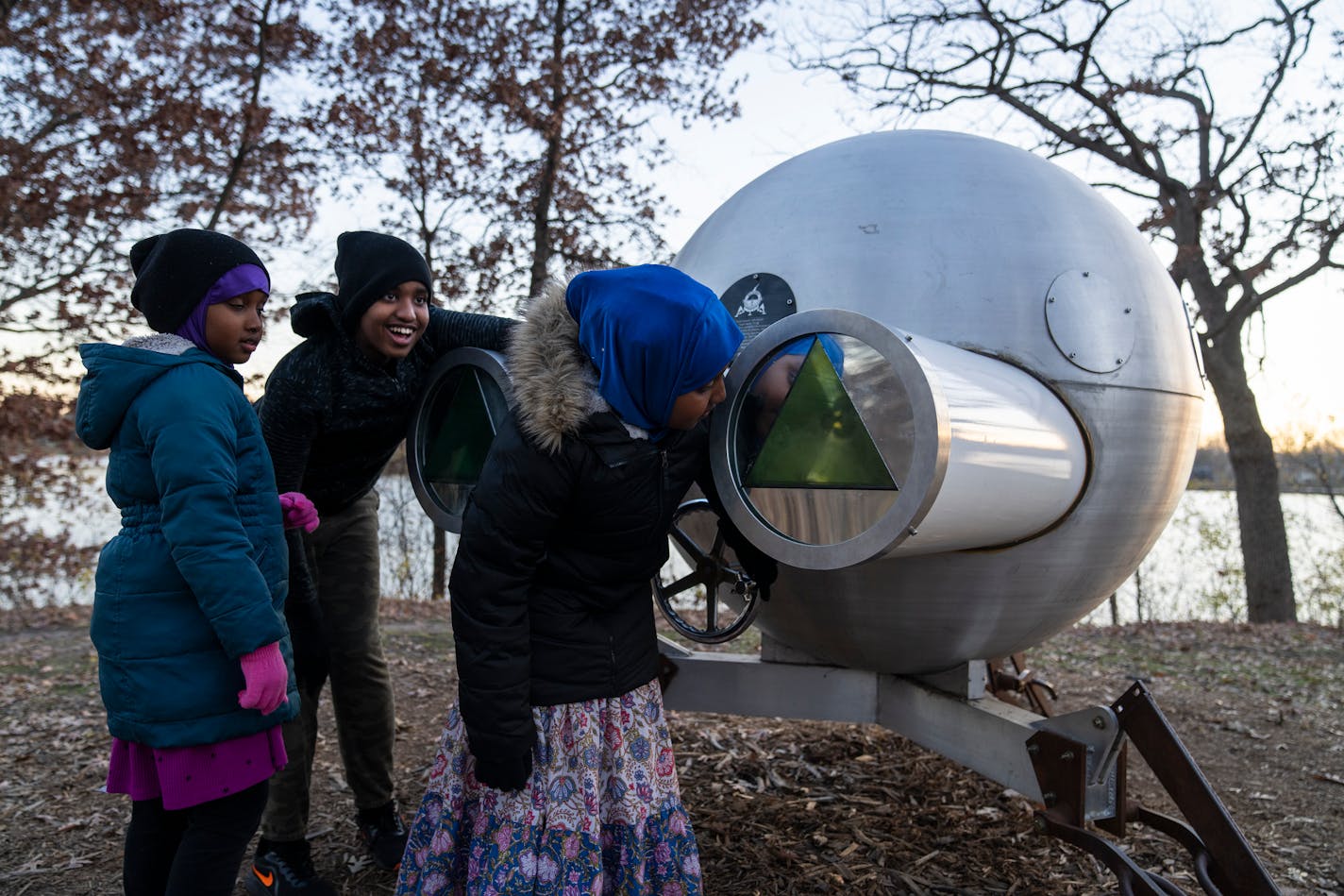 Siblings Huda Iman, 7, from left, Abdulahli, 12, and Ahlam, 10, of Roseville interact with a sculpture at Silverwood Park in St. Anthony, Minn. on Friday, Nov. 17, 2023. ] LEILA NAVIDI • leila.navidi@startribune.com