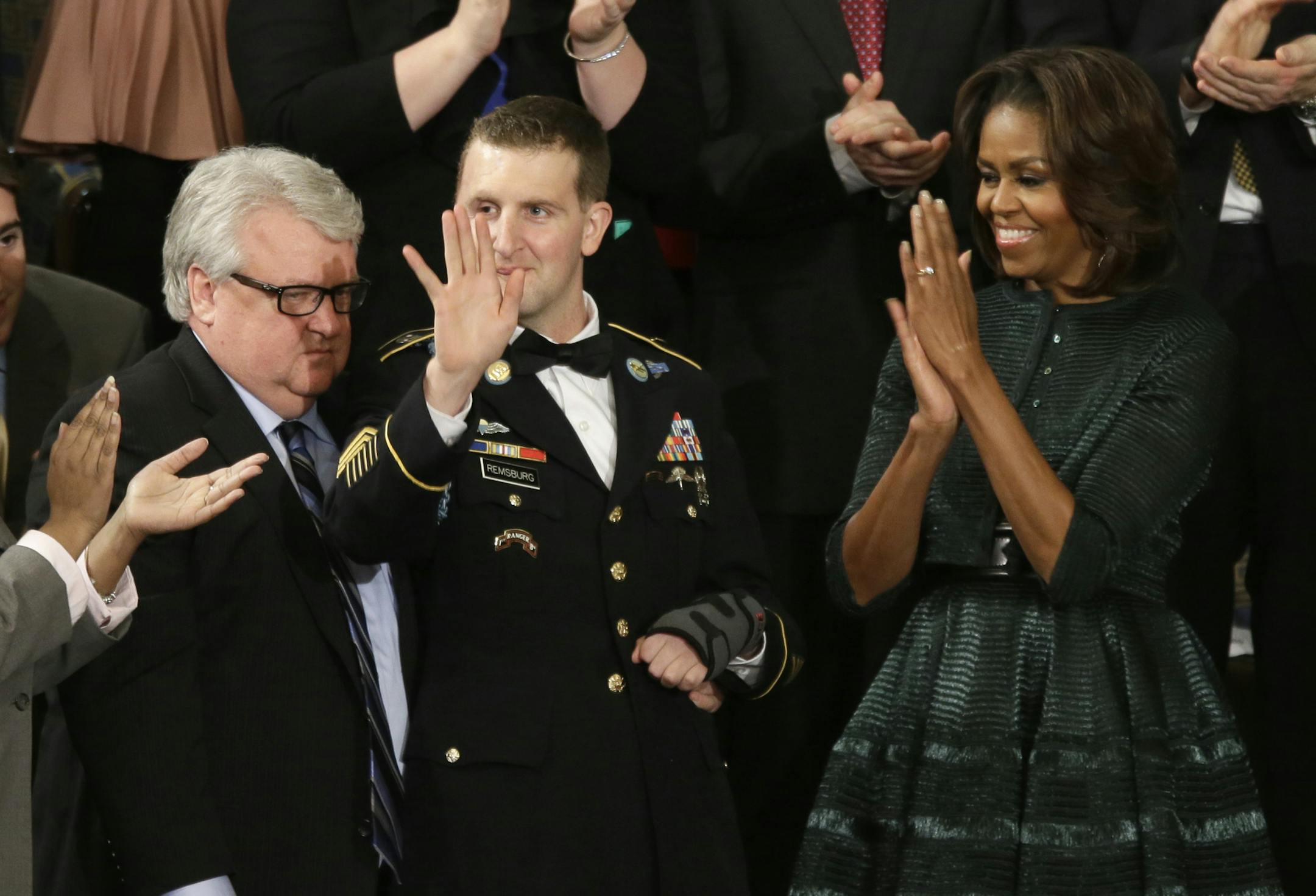First lady Michelle Obama, and others, applaud Army Ranger Sgt. 1st Class Cory Remsburg as President Barack Obama acknowledges him during his State of the Union address on Capitol Hill in Washington, Tuesday Jan. 28, 2014. (AP Photo/J. Scott Applewhite) ORG XMIT: CAP161