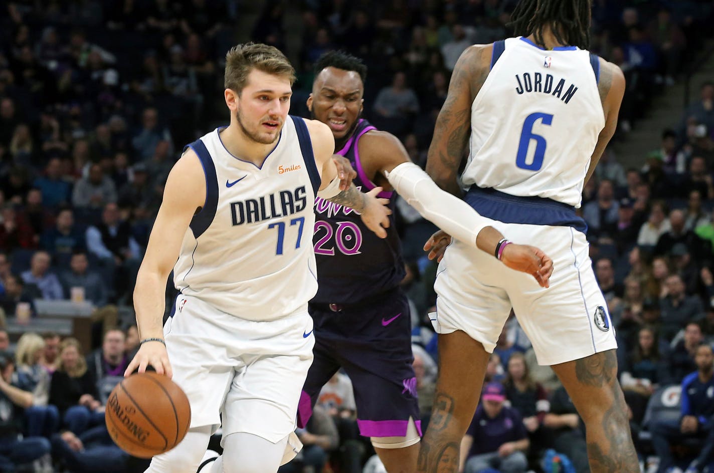 Dallas Mavericks' Luka Doncic, left, of Slovenia, drives as teammate DeAndre Jordan, right, sets a pick on Minnesota Timberwolves' Josh Okogie, of Nigeria, in the second half of an NBA basketball game Friday, Jan. 11, 2019, in Minneapolis. (AP Photo/Jim Mone)