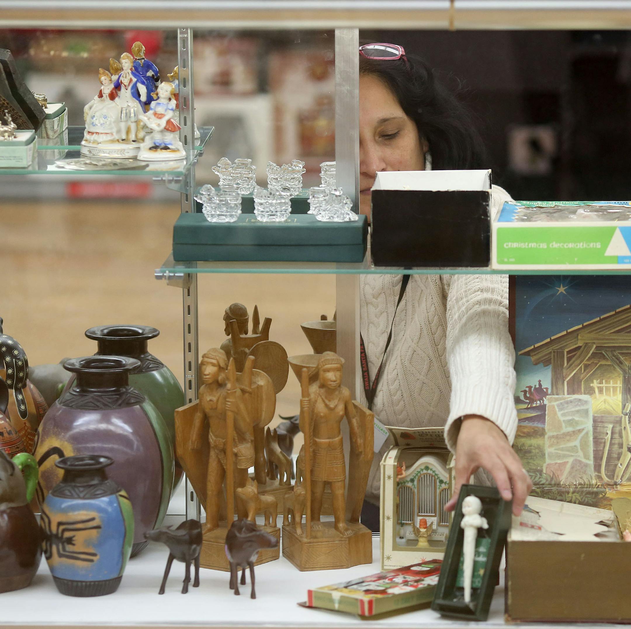 Carol Sandoval arraigned items in the display case as she and other employees and volunteers got ready for their opening. ] (KYNDELL HARKNESS/STAR TRIBUNE) kyndell.harkness@startribune.com Arc's Value Village preparing for opening in Bloomington , Min., Friday, November 21, 2014.
