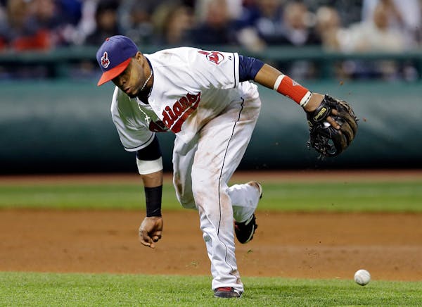 Cleveland Indians third baseman Carlos Santana fails to bare-hand a ground ball by Minnesota Twins' Sam Fuld in the seventh inning of a baseball game 