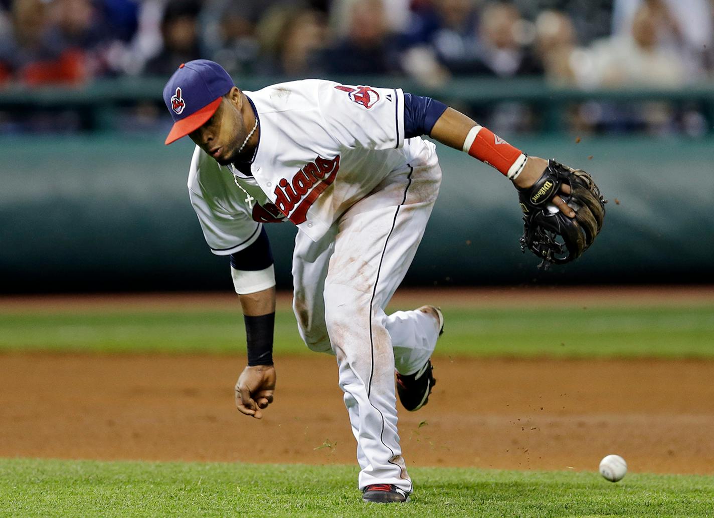 Cleveland Indians third baseman Carlos Santana fails to bare-hand a ground ball by Minnesota Twins' Sam Fuld in the seventh inning of a baseball game Wednesday, May 7, 2014, in Cleveland. (AP Photo/Mark Duncan)