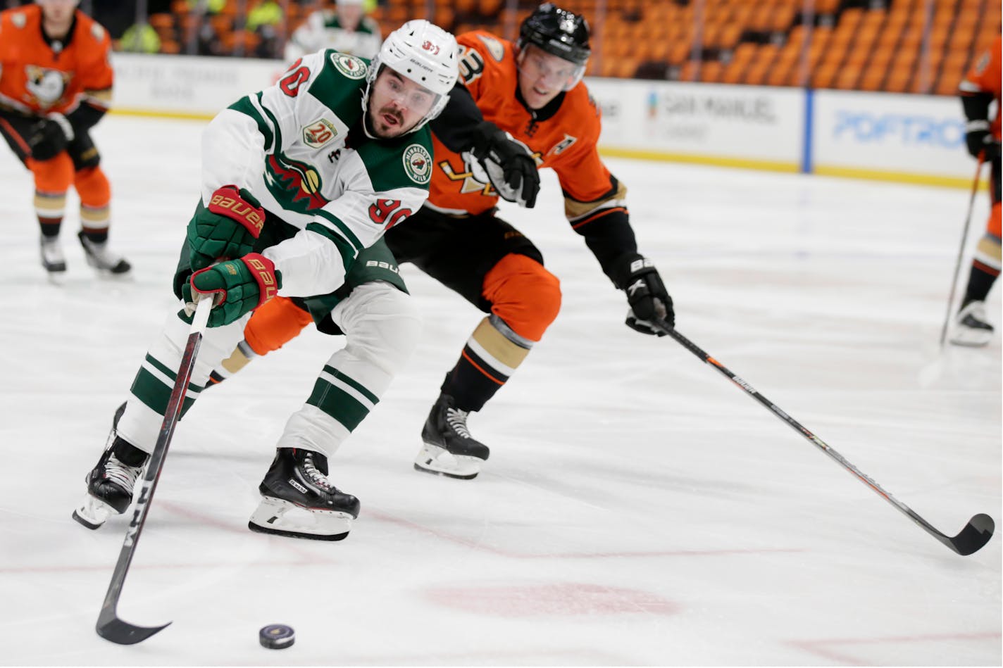 Minnesota Wild center Marcus Johansson, left, controls the puck against Anaheim Ducks right wing Jakob Silfverberg, right, during the first period of an NHL hockey game in Anaheim, Calif., Thursday, Feb. 18, 2021. (AP Photo/Alex Gallardo)