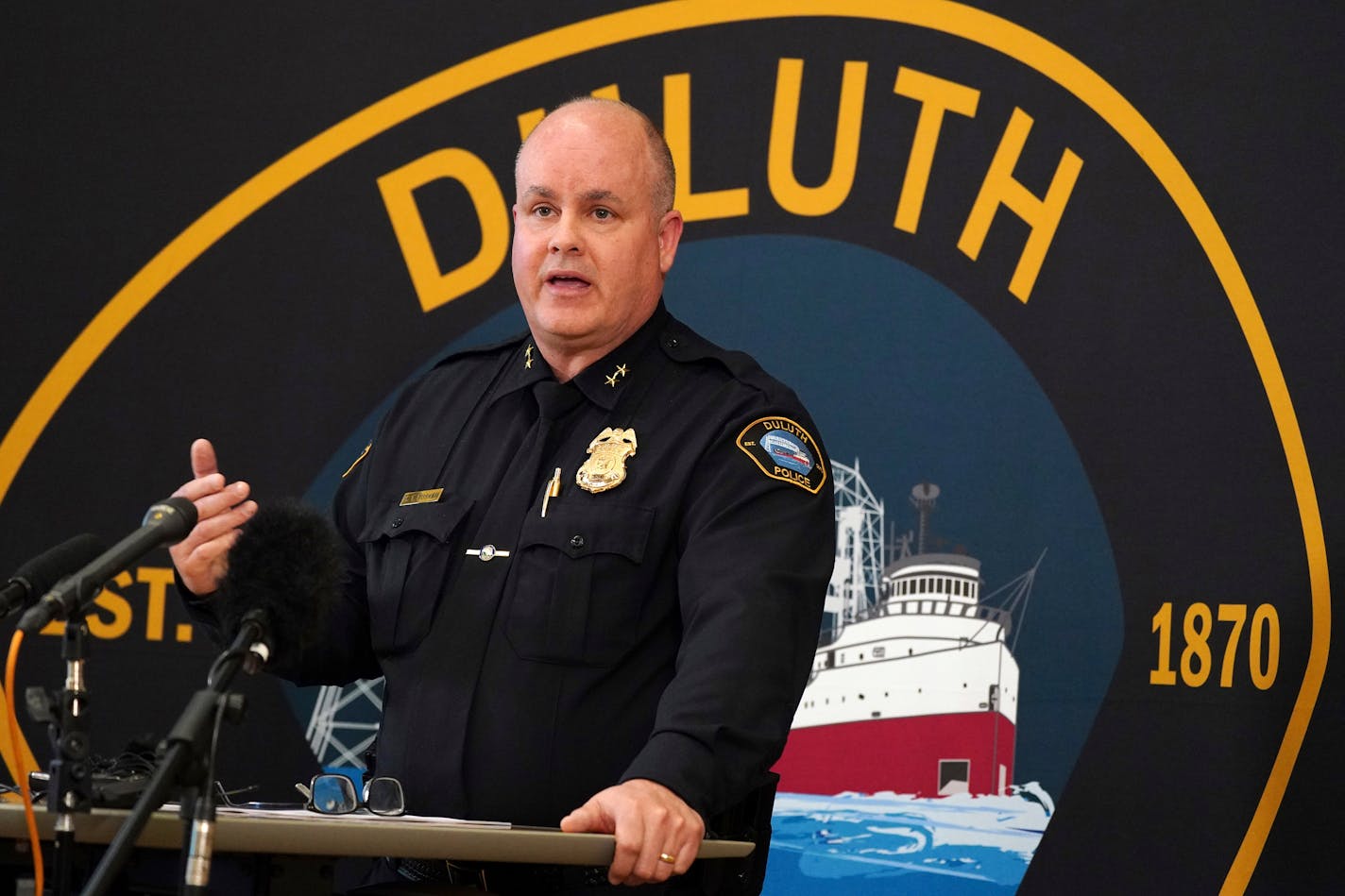 Duluth Police Chief Mike Tusken speaks from the podium during a press conference to speak about the scene the day prior where five people and a dog were found dead of gunshot wounds inside a home on East 12th Street after police received a report of a male experiencing a mental health crisis Thursday, April 21, 2022, in Duluth, Minn. Tusken said at the news conference that Brandon Taylor Cole-Skogstad, 29, killed his relatives in their beds sometime Tuesday night, and then shot himself as police knocked on the door around 12:30 p.m. Wednesday. (Anthony Souffle/Star Tribune via AP)