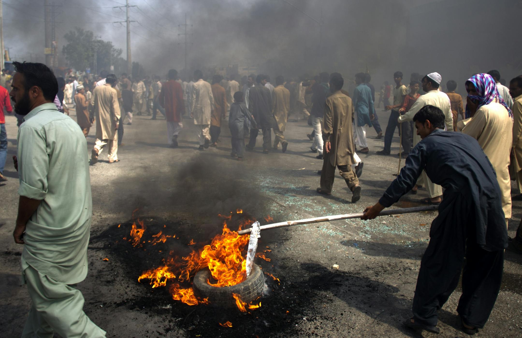 Pakistani protesters burn tires to block the main highway in Rawalpindi, Pakistan on Friday, Sept. 21, 2012. Pakistan has blocked cell phone service in major cities to prevent militants from using phones to detonate bombs during a national day of protest against an anti-Islam film produced in the United States.