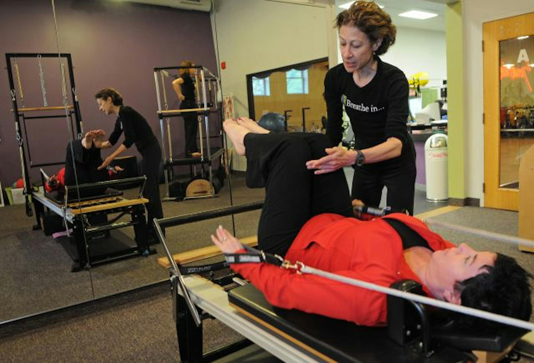 Nicole DePalma instructed Kayleen Caulfield during a private Pilates session. DePalma was laid off from the YMCA last year but now gets retraining tuition from the state for other Pilates certifications.