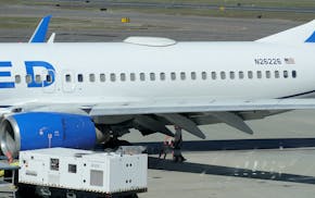 A Medford Jet Center worker walks under a United Boeing 737-824 that landed at Rogue Valley International-Medford Airport from San Francisco with a mi