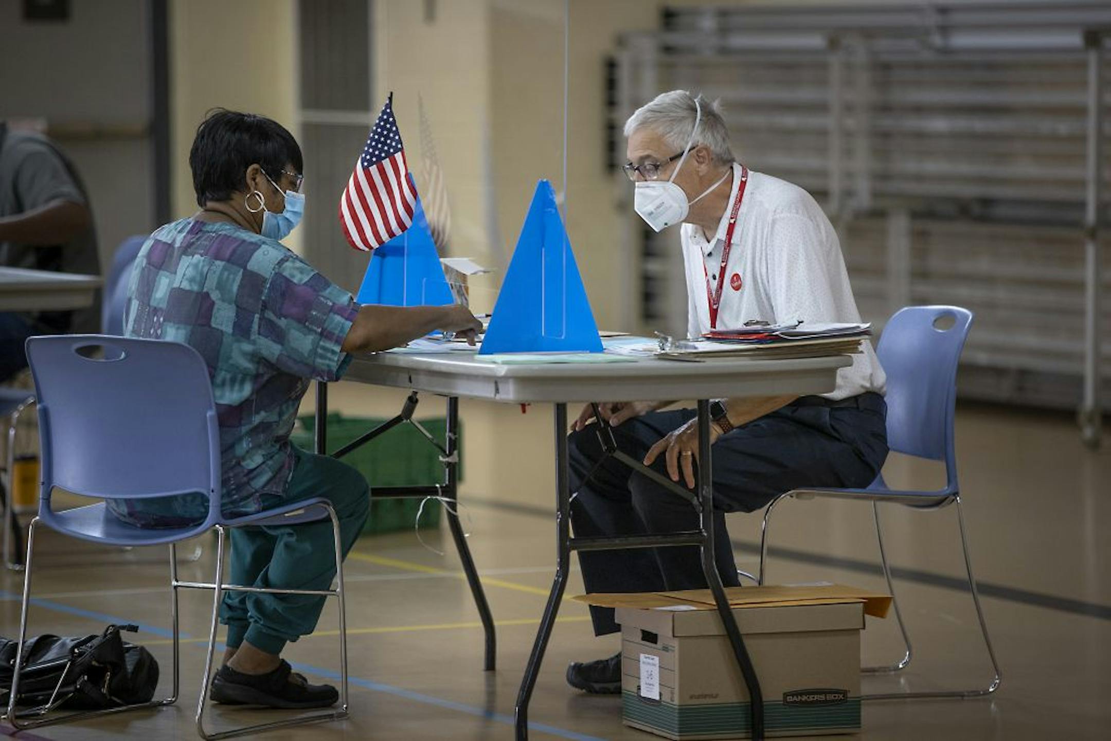 Election volunteer Wil Totten, cq, right, helped voter Doris Scroggins, cq, with her ballot at the Jimmy Lee Recreation Center polling location, Tuesday, August 11, 2020 in St. Paul, MN.