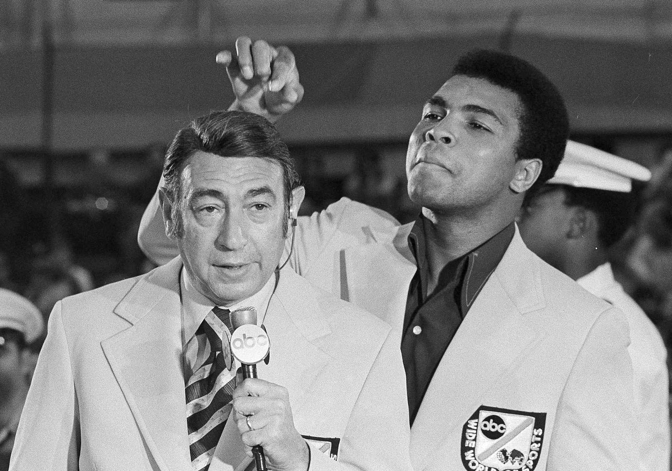 Muhammad Ali, former world heavyweight boxing champion, toys with the finely combed hair of television sports commentators Howard Cosell before the start of the Olympic boxing trials, Aug. 7, 1972, in West Point, NY. (AP Photo) ORG XMIT: APHS278575A