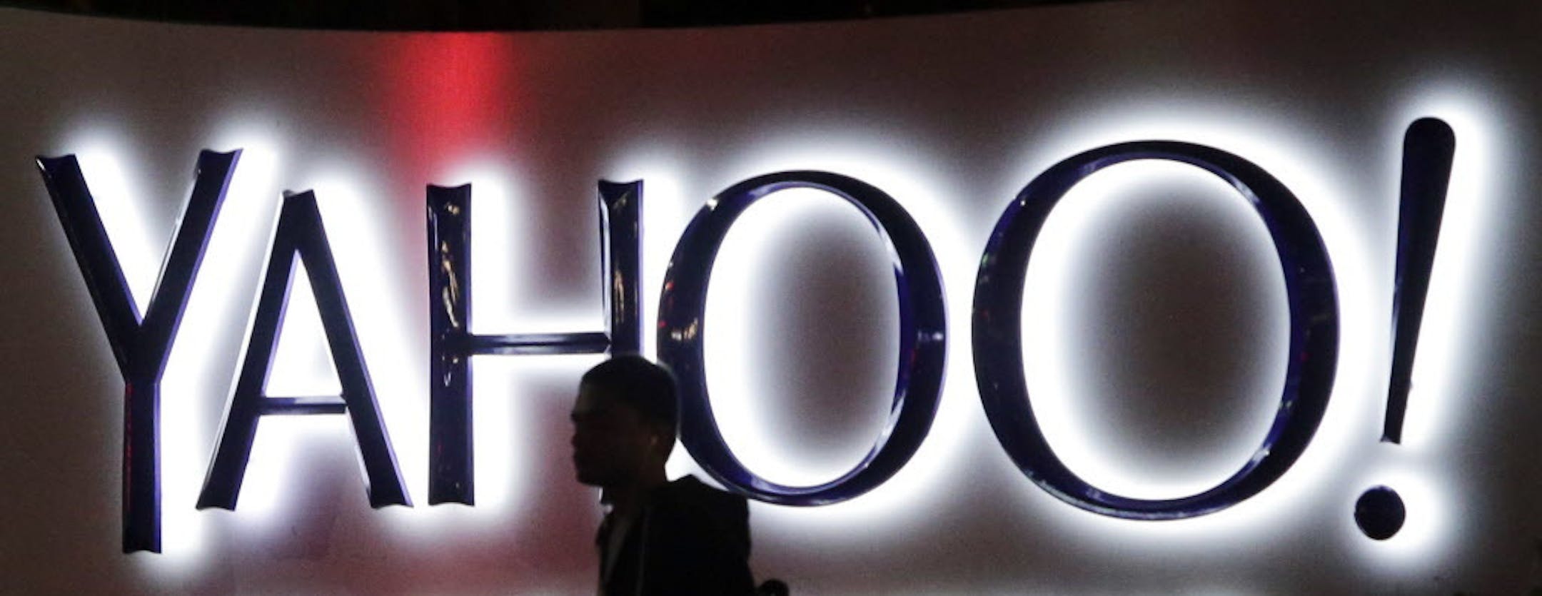 FILE - In this Nov. 5, 2014, file photo, a person walks in front of a Yahoo sign at the company's headquarters in Sunnyvale, Calif. Verizon has agreed to buy online portal Yahoo Inc. for roughly $5 billion, according to multiple media reports sourcing unnamed sources. The deal is expected to be announced formally on Monday, July 25, 2016, before markets open. (AP Photo/Marcio Jose Sanchez, File)