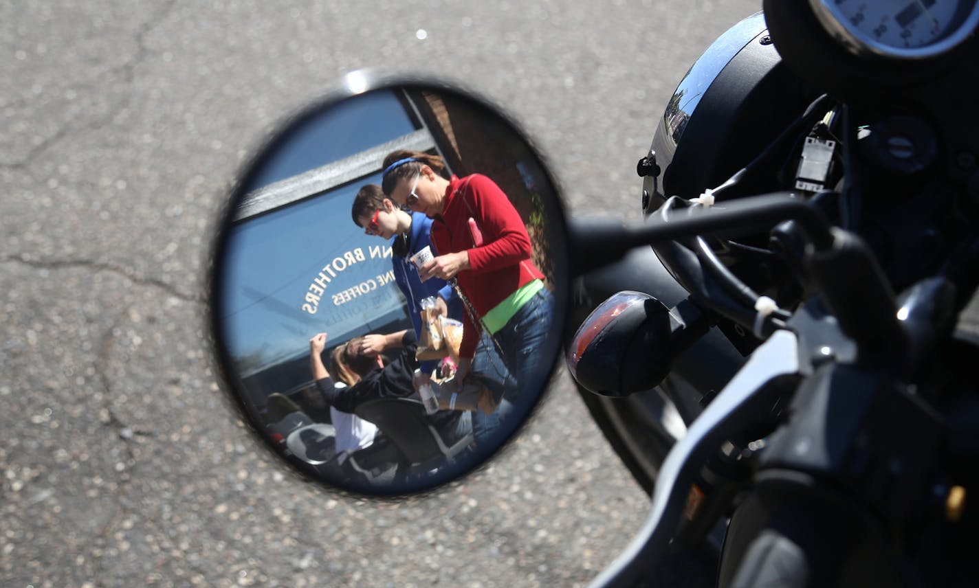 Viewed from a reflection of a motorcycle mirror, customers sat outside of the Dunn Bros on Grand Ave while pedestrians walked by. ] (KYNDELL HARKNESS/STAR TRIBUNE) kyndell.harkness@startribune.com On Grand Avenue in St Paul Min., Thursday October 1, 2015. St. Paul's plan to test metered parking on Grand Avenue, the city's best known commercial strip, has merchants and businesses seeing red. The council is expected to approve the measure in mid-October.