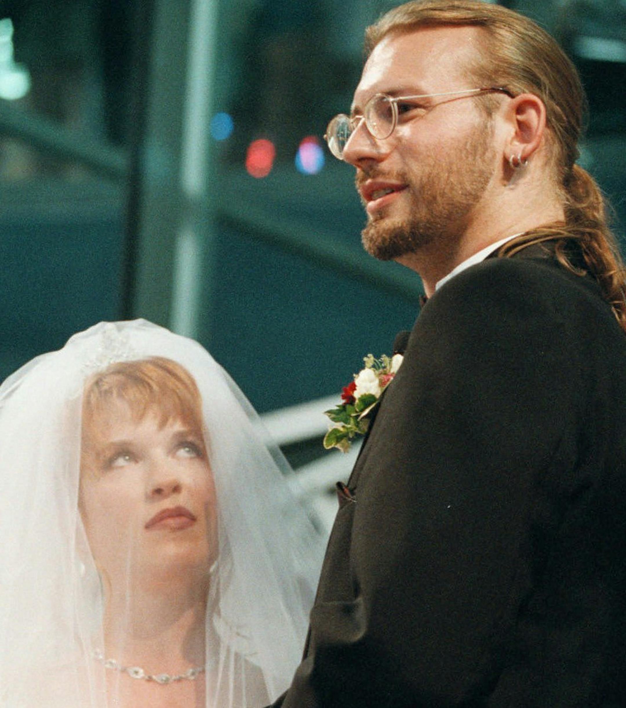 FILE - In this June 13, 1998 file photo, Elizabeth Runze looks up as David Weinlick says, "I do" during their wedding ceremony at Mall of America in Bloomington, Minn. Weinlick's family and friends picked Runze from a group of 23 possible brides less than two hours before the wedding. The Minnesota couple who began their life together through an arranged marriage nearly 20 years ago are about to renew their vows. The ceremony on Friday, Aug. 18, 2017 will again be at the Mall of America. (AP Pho