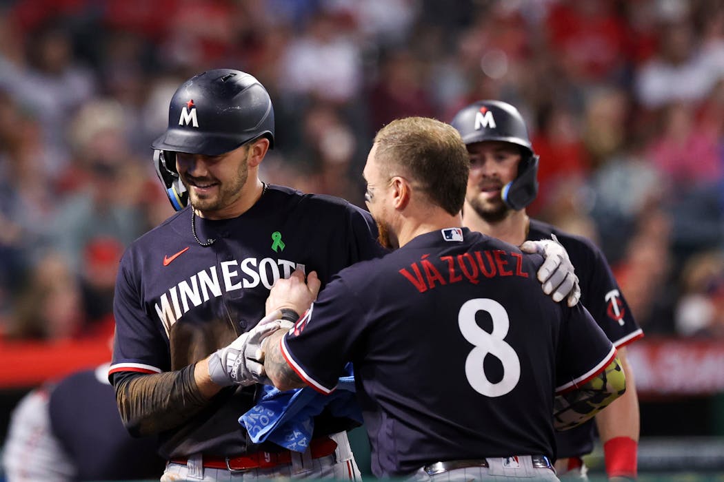 Trevor Larnach celebrated with Christian Vazquez after scoring off a throwing error by Los Angeles Angels second baseman Brandon Drury during the seventh inning Saturday in Anaheim, Calif.