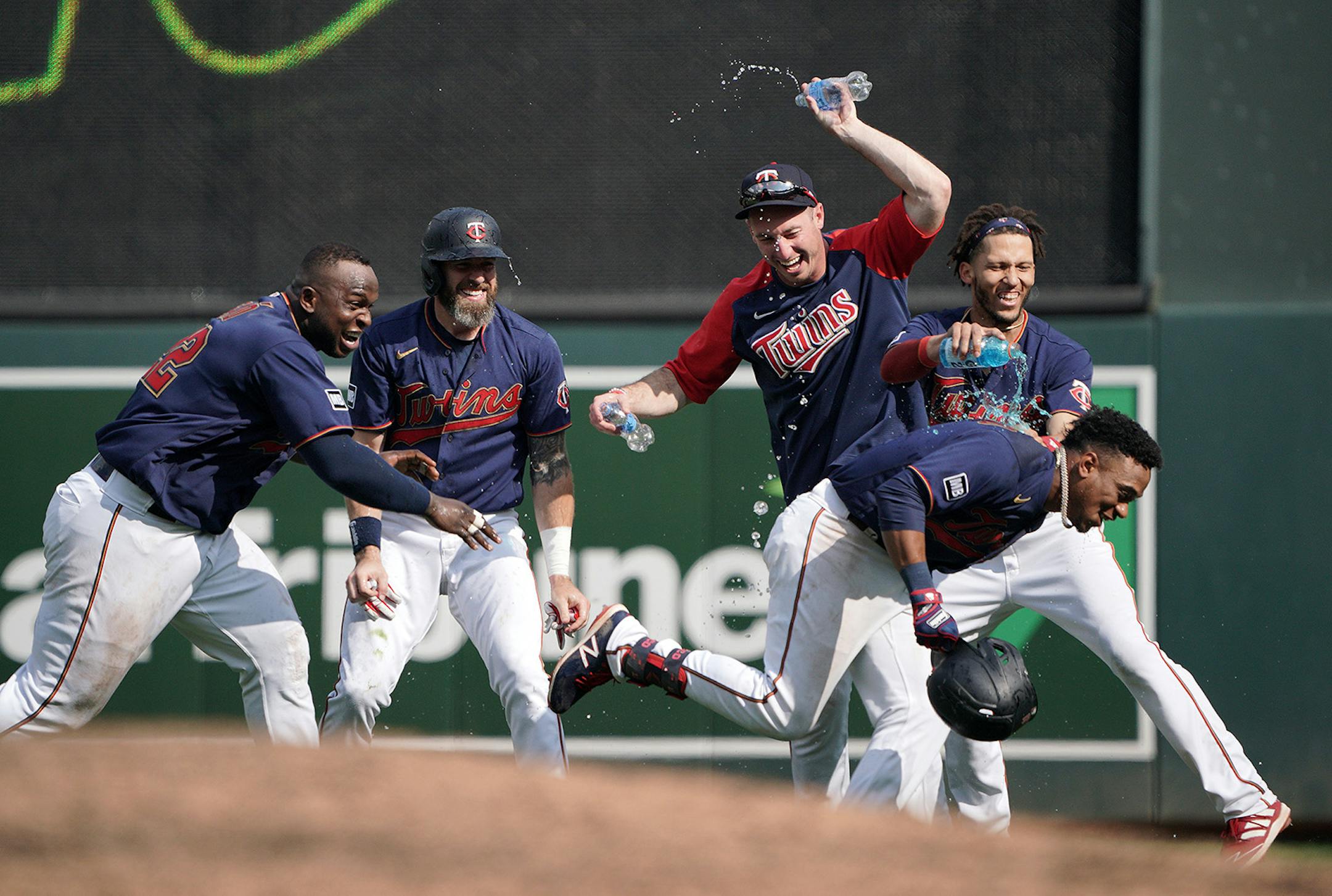 Minnesota Twins' Jorge Polanco, (left right), gets a water shower from his teammates after his bases-loaded, walk off single drove in the winning run in the 11th inning as the Twins beat the Cleveland Indians 8-7.
