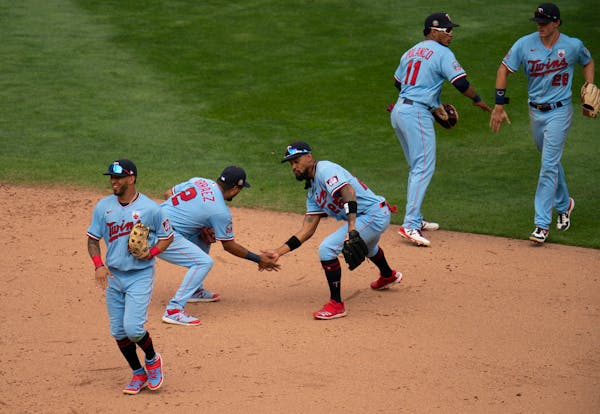 Twins second baseman Luis Arraez (2) and center fielder Byron Buxton (25) low-fived after a Twins win on Aug. 16.