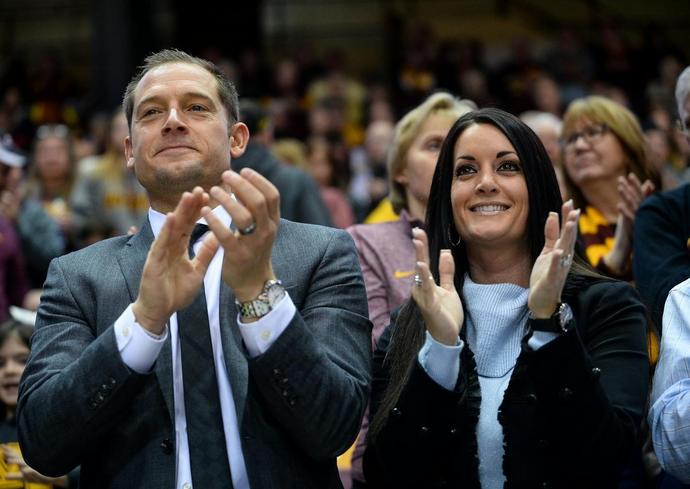 New Minnesota Golden Gophers football head coach P.J. Fleck and wife Heather Fleck clapped along during the Gophers fight song Saturday night at the end of the first half of the women's basketball game against the Wisconsin Badgers.