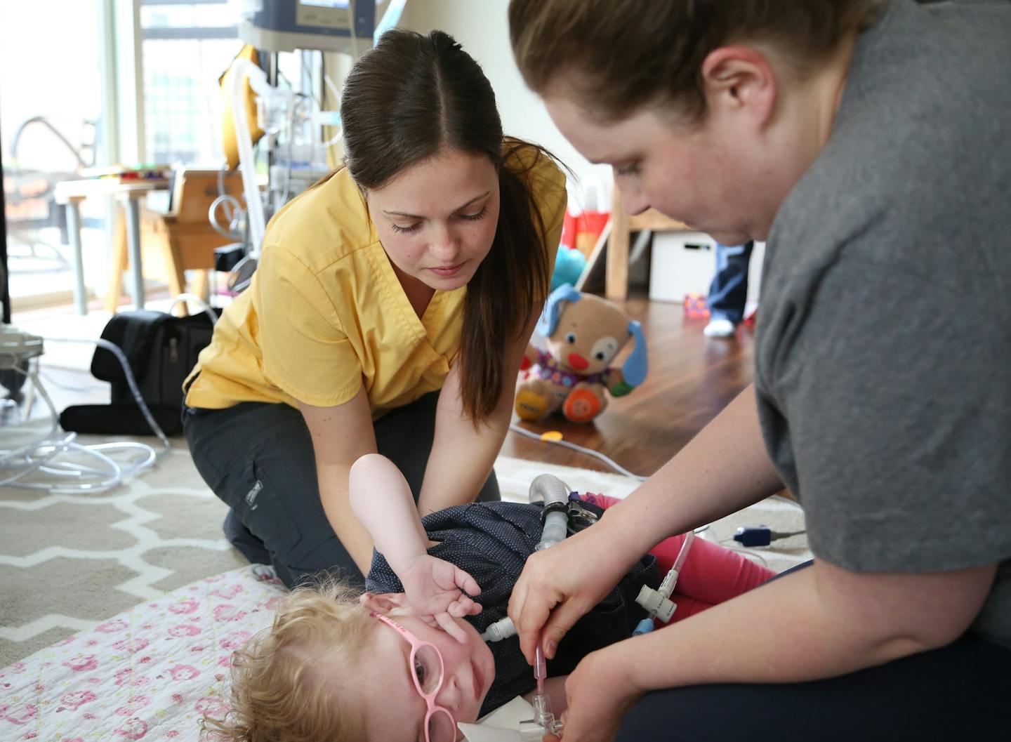 RN Lindsay Powell left helped Sara Raunaas give treatment to her daughter Elsa Raunaas at their condo Wednesday May 20, 2015 in Minneapolis, MN. Lindsay is a nurse at Pediatric Home services, a company that has been named one of the top 3 workplaces. Jerry Holt/ Jerry.Holt@Startribune.com