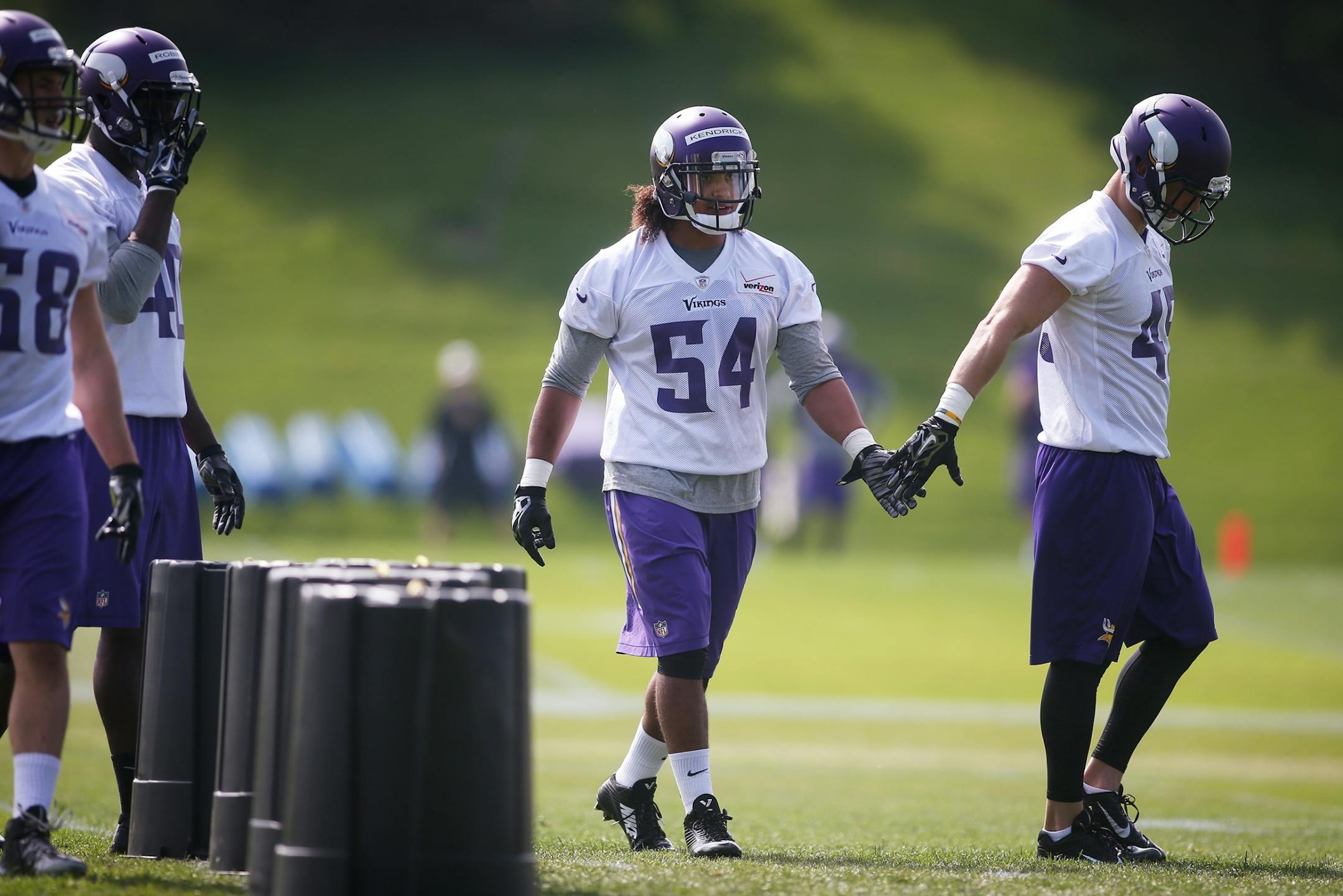 Rookies Eric Kendricks, center, and Brian Peters, right, slap hands during Vikings 2015 rookie minicamp.