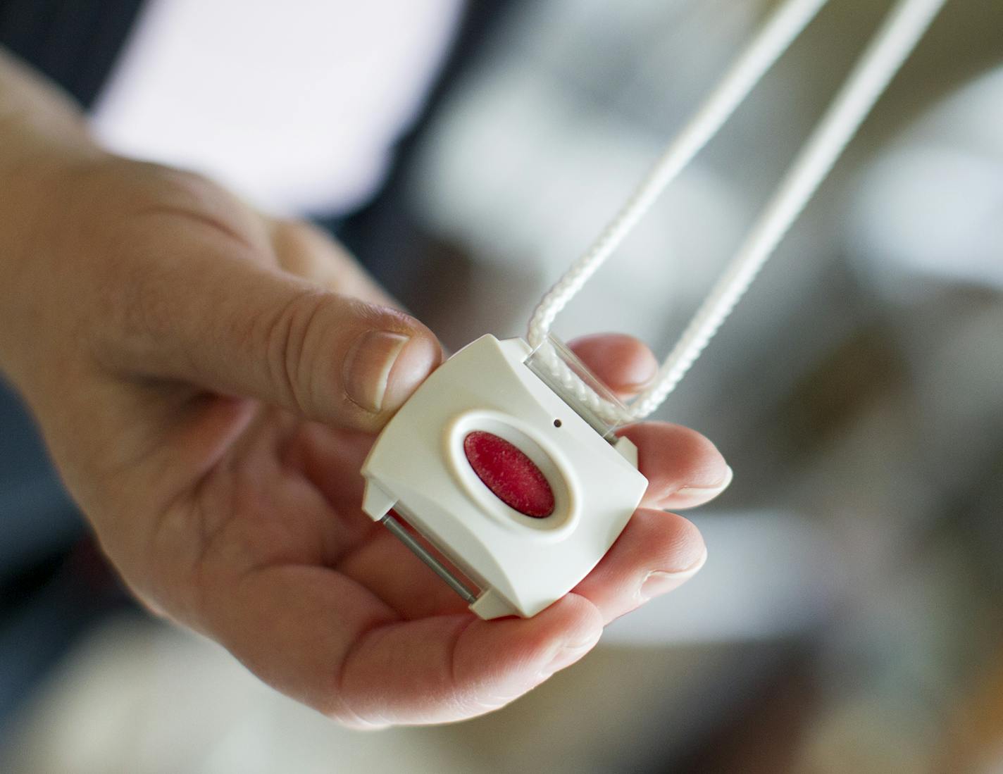 The Healthsense eNeighbor system offers emergency buttons, such as this one that can be worn around the neck, as well as motion detectors in living spaces. Photographed at the Evans residence in St. Paul December 15, 2015. (Courtney Perry/Special to the Star Tribune)