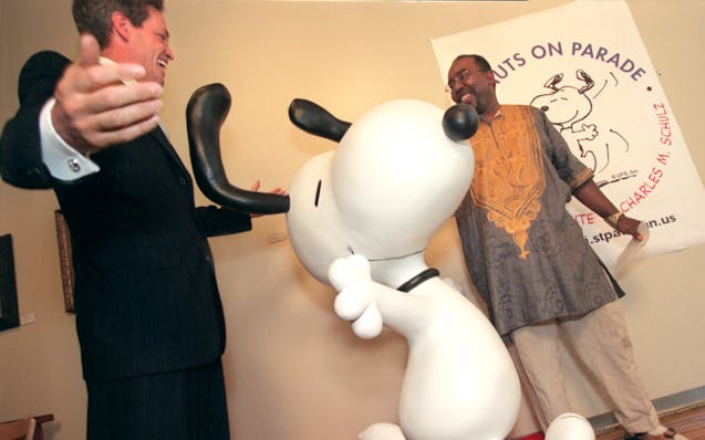 Then-Mayor of St. Paul Norm Coleman and Lowertown artist Ta-coumba T. Aiken unveiled a statue of Snoopy at the Black Dog Cafe in 2000.