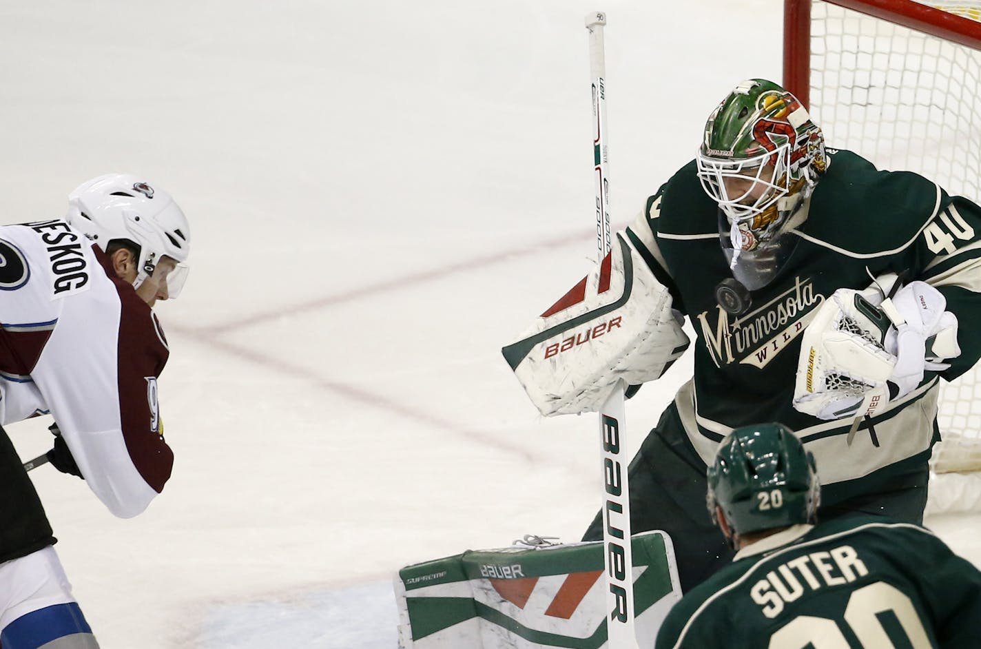 Minnesota Wild goalie Devan Dubnyk (40) deflects a shot by Colorado Avalanche left wing Gabriel Landeskog, left, of Sweden, during the first period of an NHL hockey game in St. Paul, Minn., Saturday, Dec. 5, 2015. (AP Photo/Ann Heisenfelt)