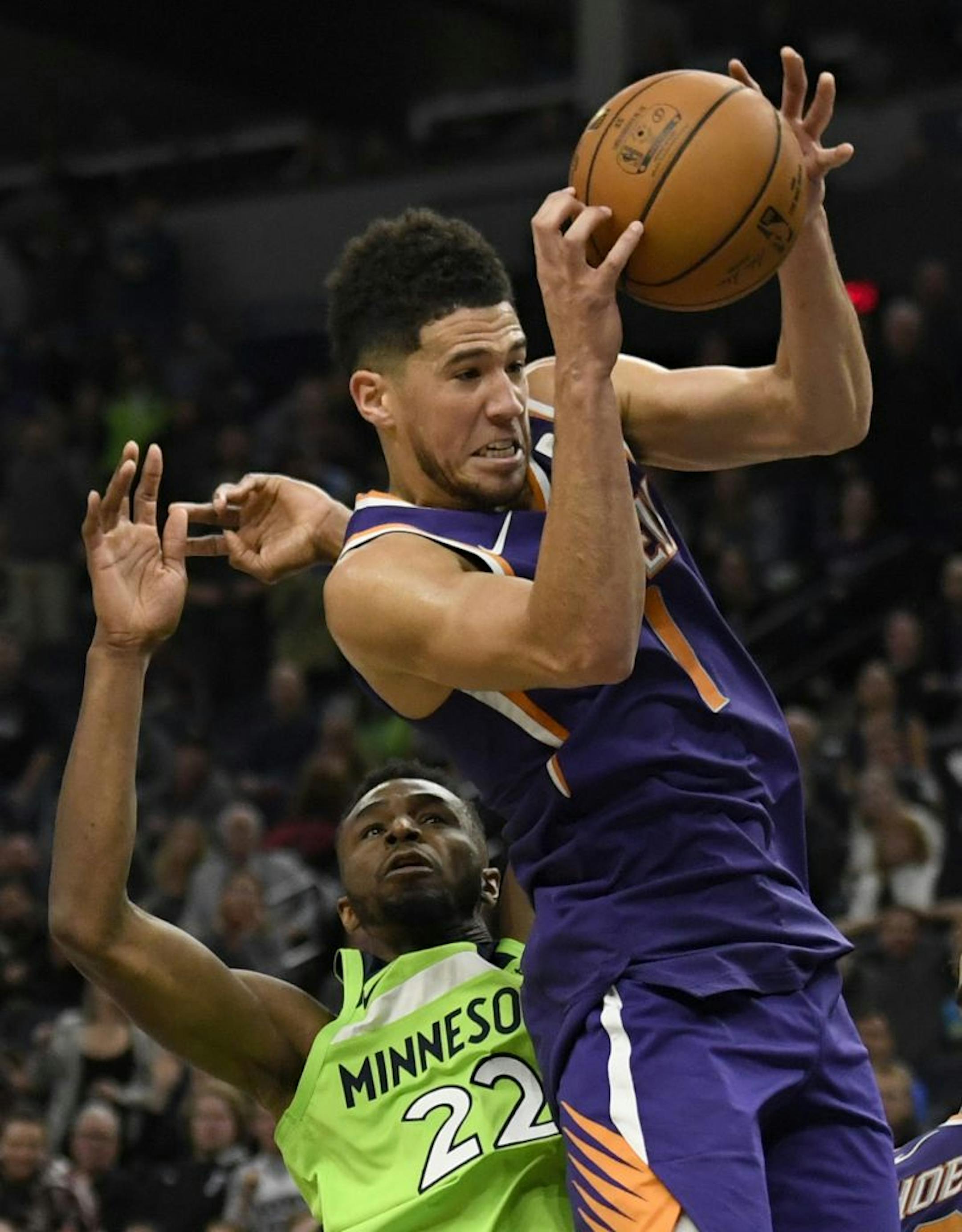 Phoenix Suns' Devin Booker (1) reaches for a rebound next to Minnesota Timberwolves' Andrew Wiggins (22) in the final minute of an NBA basketball game Saturday, Nov. 23, 2019, in Minneapolis. The Suns won 100-98.