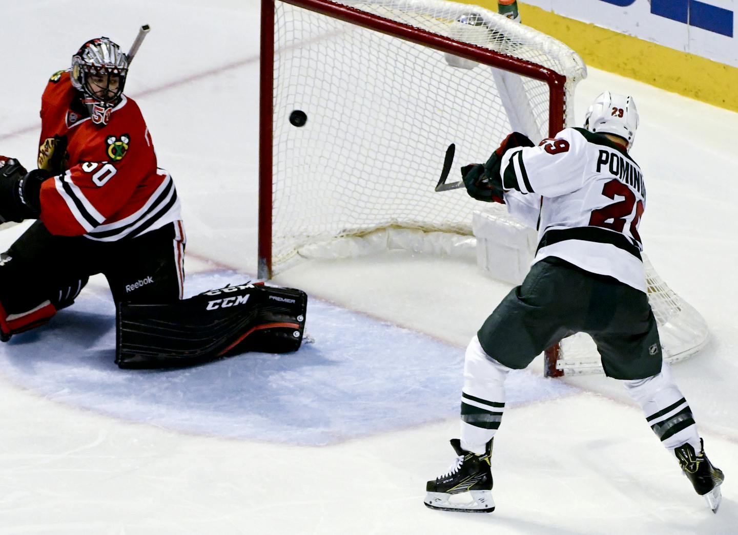 Chicago Blackhawks goalie Corey Crawford (50) looks on as Minnesota Wild right wing Jason Pominville (29) scores the game winning goal during the third period of an NHL hockey game on Sunday, Jan. 15, 2017, in Chicago. (AP Photo/Matt Marton)