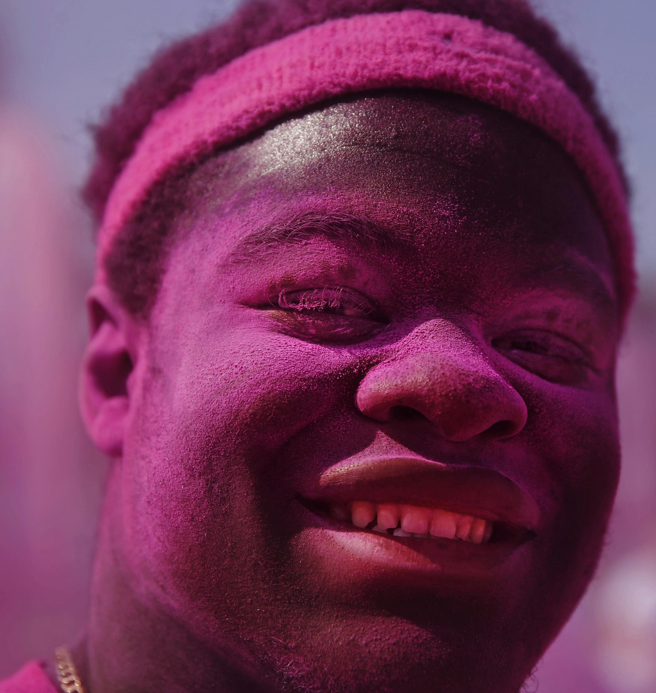 Kez Flomo was one of the volunteers who enjoyed dousing the runners/walkers in magenta dyed cornstarch. See more photos at www.startribune.com.