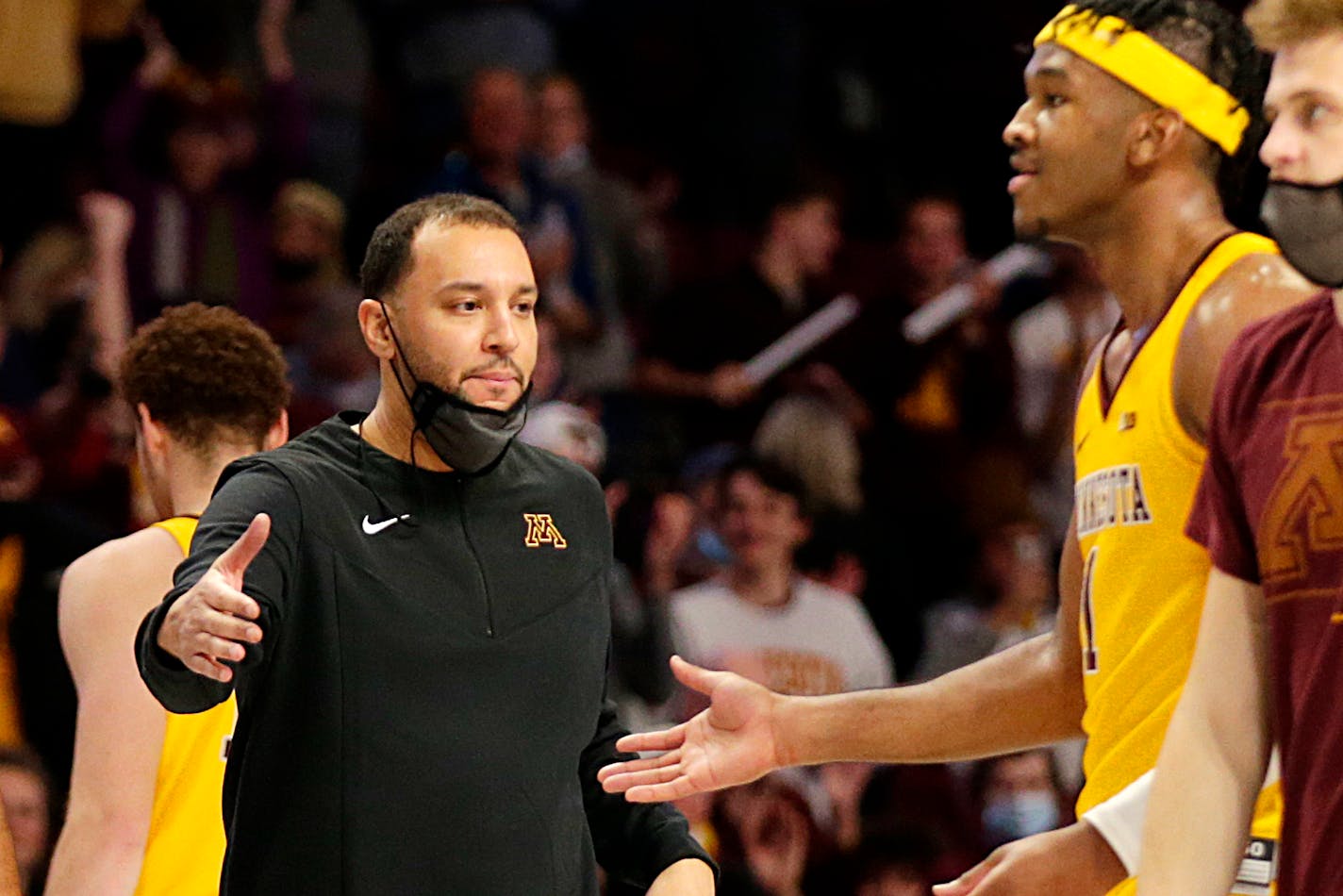 Minnesota coach Ben Johnson congratulates forward Eric Curry during a game on Nov. 9