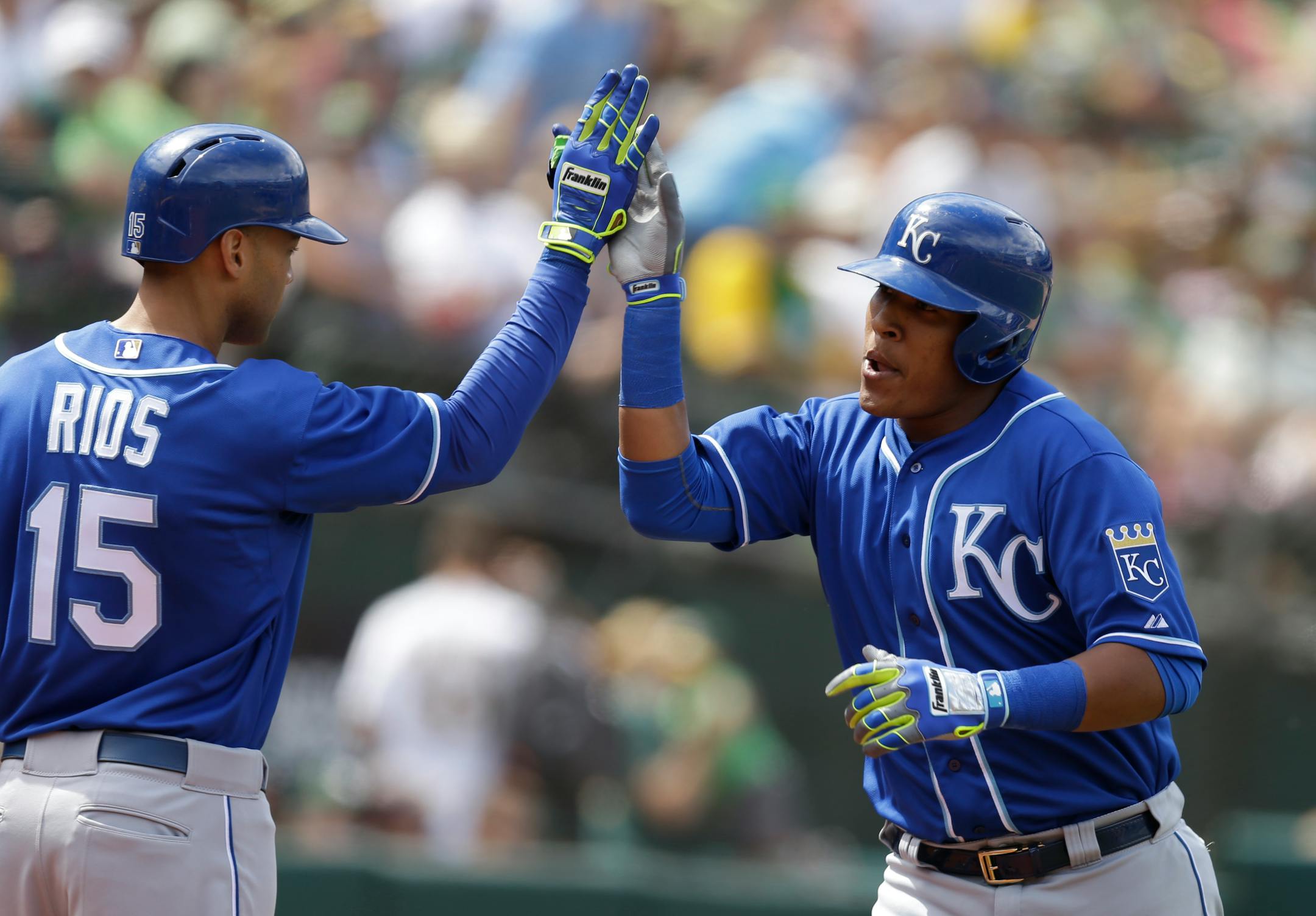 Kansas City Royals' Salvador Perez, right, celebrates with Alex Rios (15) after hitting a two-run home run off Oakland Athletics' Edward Mujica in the eighth inning of a baseball game Sunday, June 28, 2015, in Oakland, Calif. (AP Photo/Ben Margot)