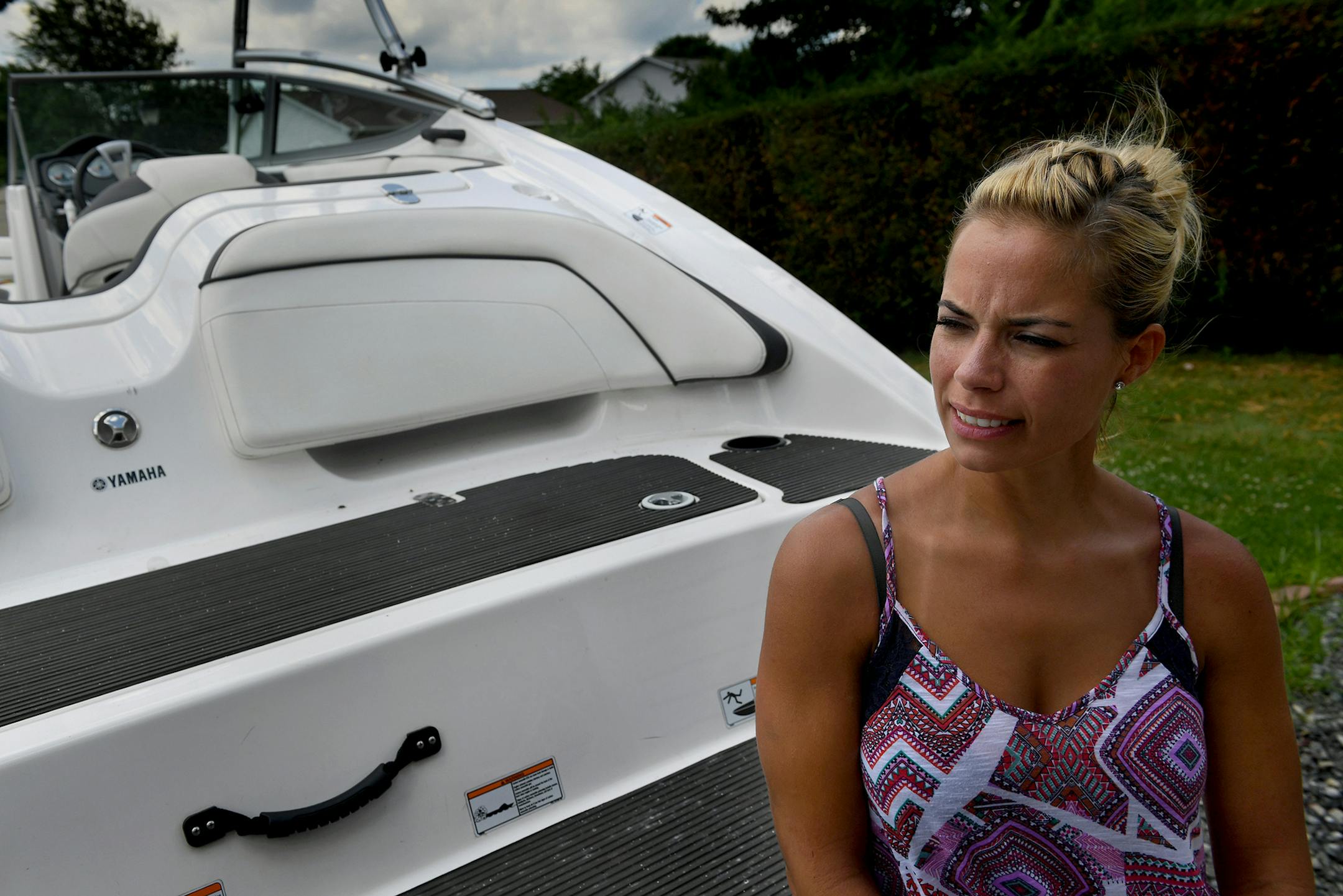 Lauren Conner with the boat from which she fell. Concern about her children and her familiarity with water helped her survive.