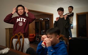 Quan Do, his brother Quang, Matvii Suminov, and Theo Krieger, 5, from left, visited after dinner in their on-campus apartment January 16, 2024 in Mend