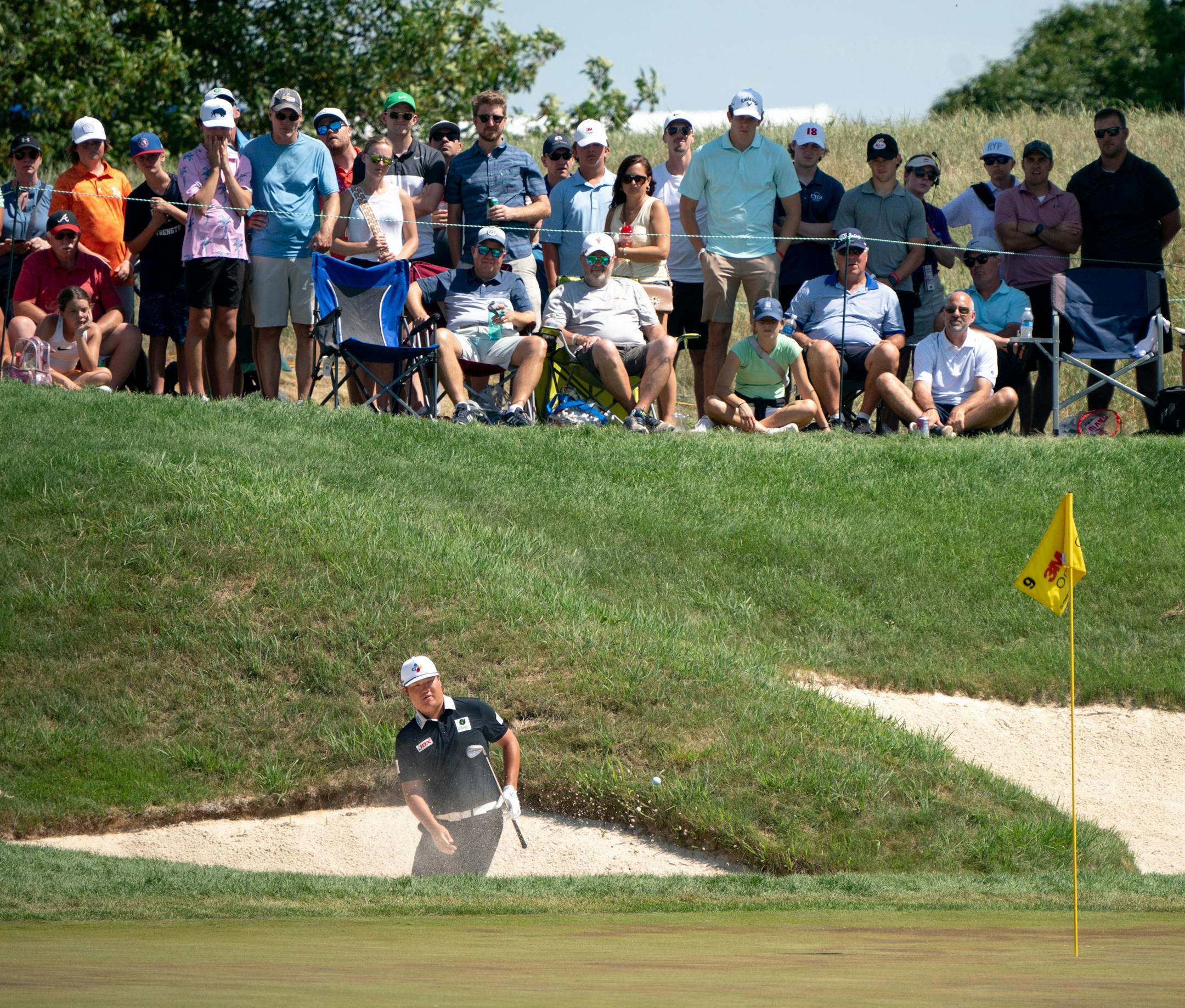 Sungjae Im takes a shot from the sand on the ninth hole while the gallery watches during the 3M Open.