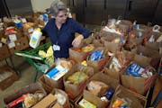 Volunteer Lisa Polzin helps pack more than 40 boxes of groceries to be delivered to area families in need of food assistance Tuesday, Jan. 16, 2024 at