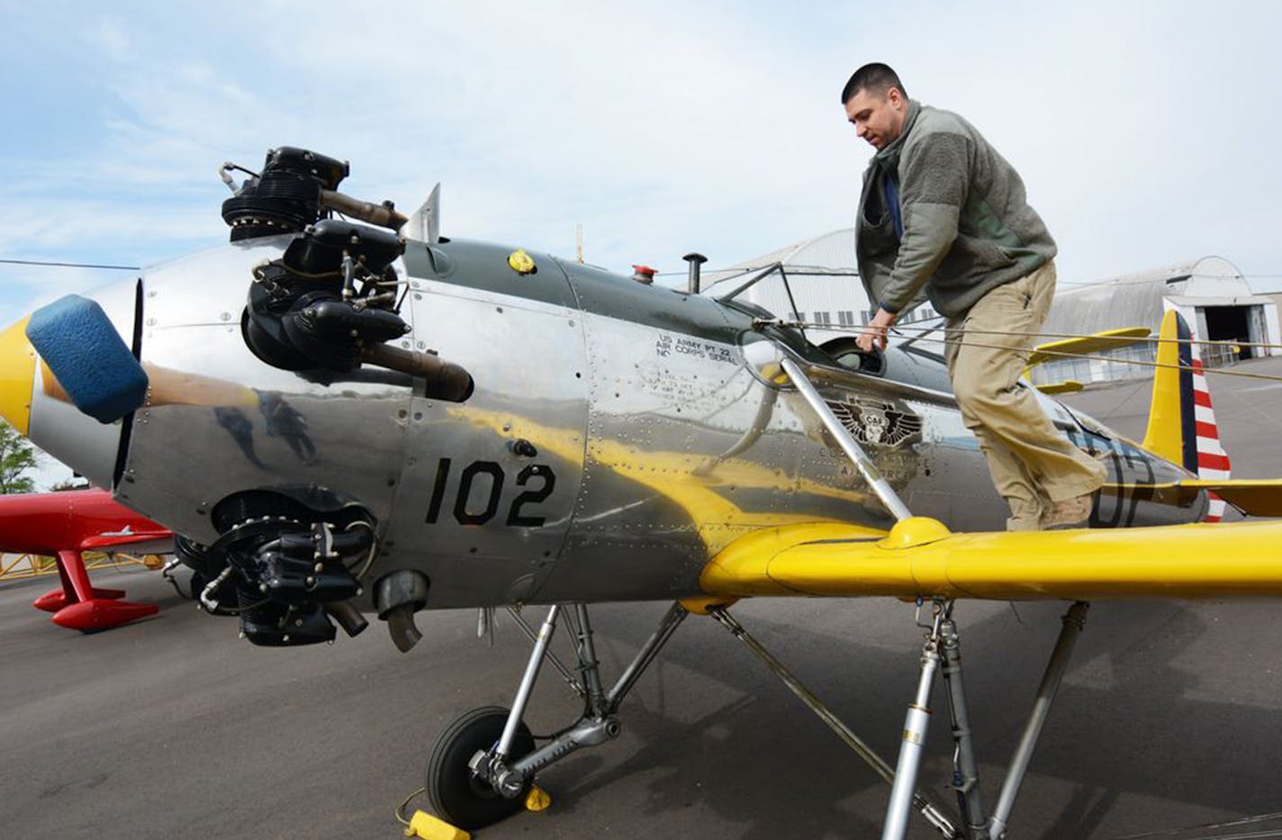 Jim Lauria climbed aboard the Ryan PT-22 Recruit, used to train pilots in World War II, while Amy Lauria watched. Both are volunteers for the Minnesota wing of the Commemorative Air Force.