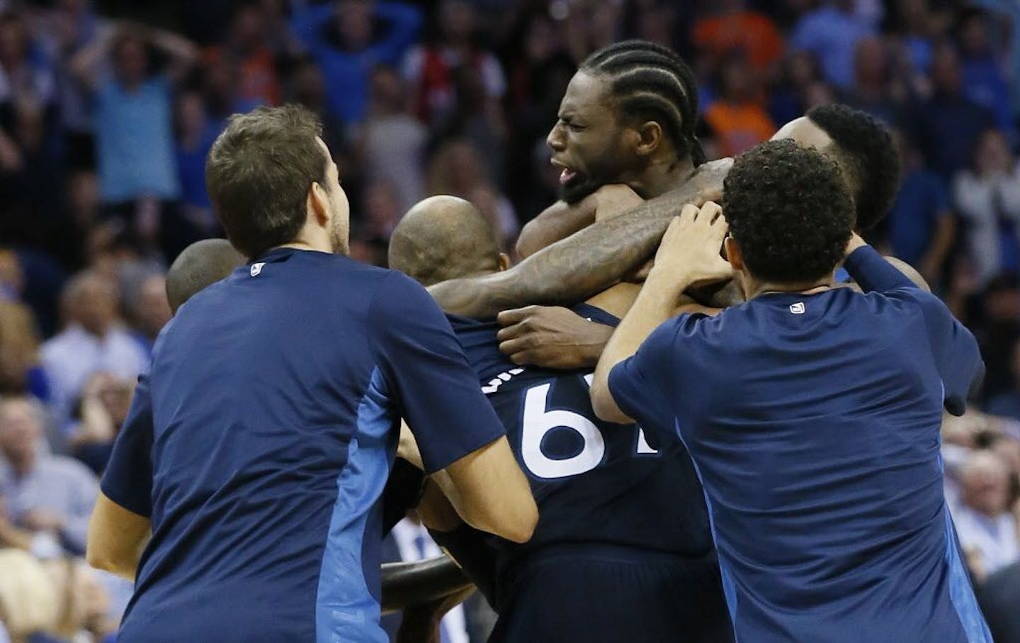 Minnesota Timberwolves guard Andrew Wiggins, center, is mobbed by his teammates after hitting the game winning shot at the buzzer in the fourth quarter of an NBA basketball game against the Oklahoma City Thunder in Oklahoma City, Sunday, Oct. 22, 2017. Minnesota won 115-113.