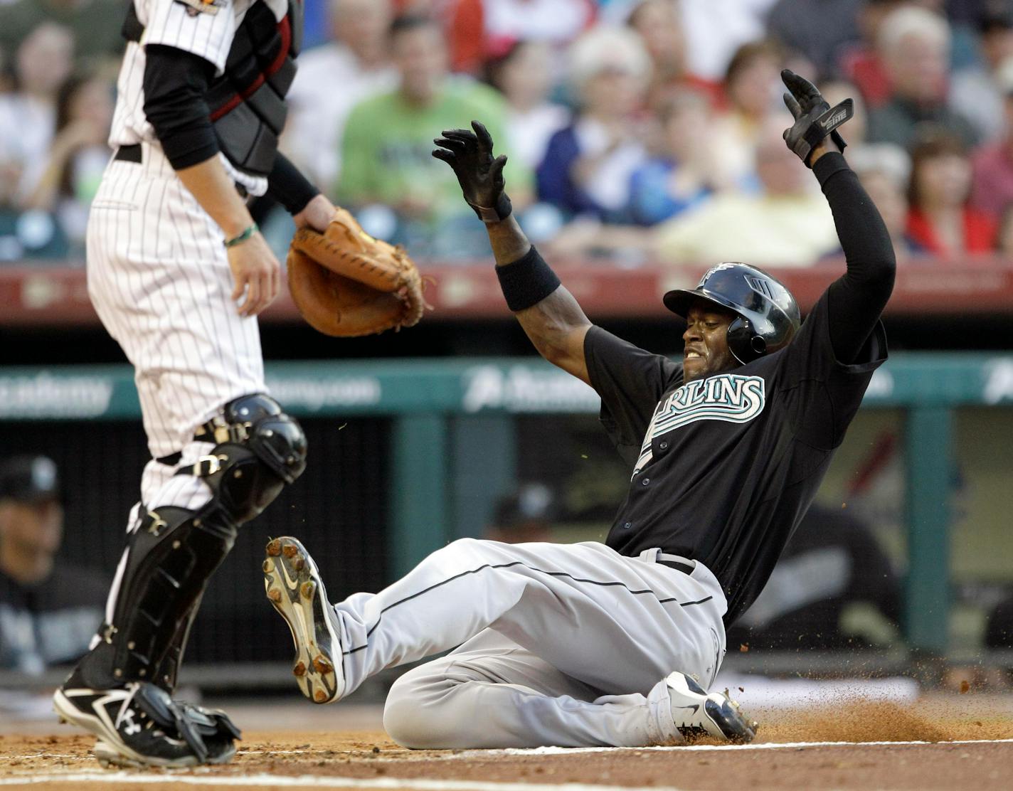 Florida Marlins' Cameron Maybin, right, slides across home plate to score on an RBI single by Hanley Ramirez as Houston Astros catcher J.R. Towles, left, waits for the throw during the first inning of a baseball game Tuesday, April 20, 2010, in Houston.