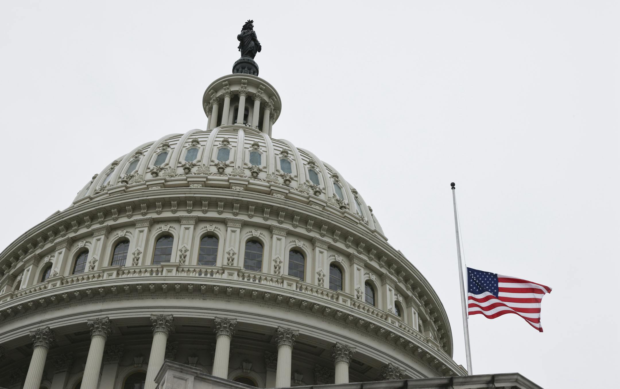 The American flag flies at half staff over the U.S. Capitol as the flag-draped casket of Justice Ruth Bader Ginsburg arrives, where Ginsburg will lie in state Friday, Sept. 25, 2020, in Washington. (Jonathan Ernst/Pool via AP)