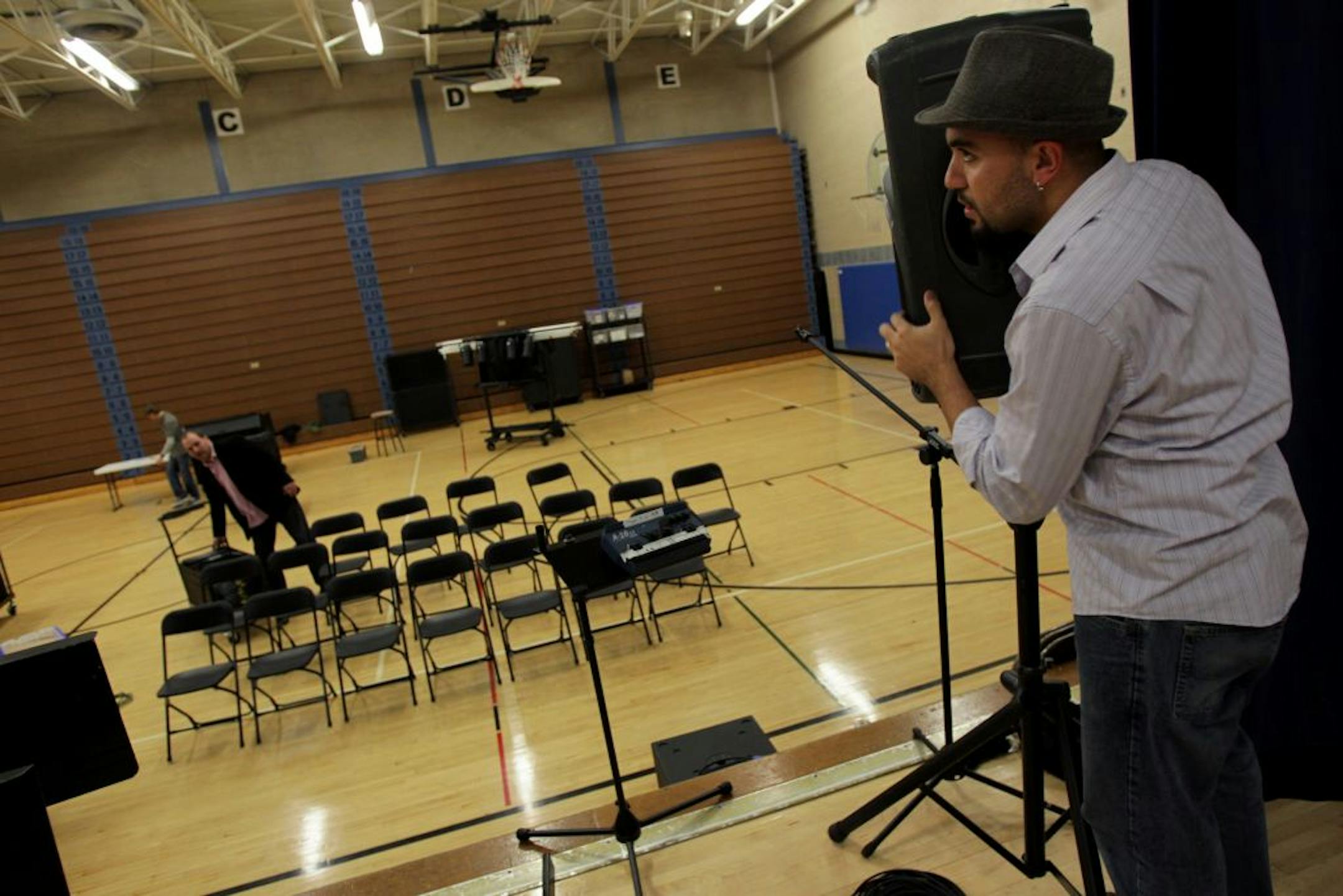 Authentic Life Church music director Josh Alfaro set up a speaker at the Hopkins West Junior High School gym before a Sunday service in Minnetonka, Minn., October 23, 2011. The church sets up and breaks down a full church set up each Sunday at the school.