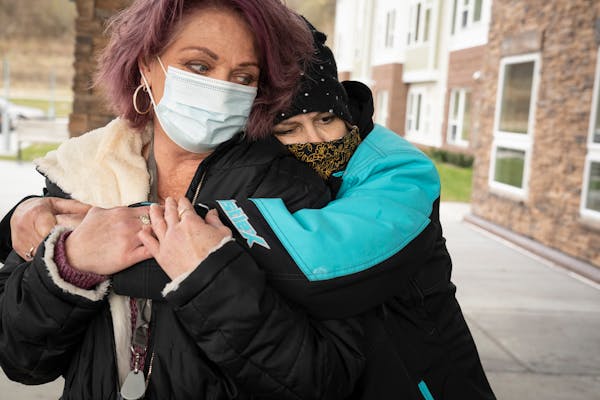 Laurie Eastwood hugs Wanda Grady, left, outside Wings of Newport apartments on Friday, Nov. 19, 2021, in Newport, Minn. They were recently told they h