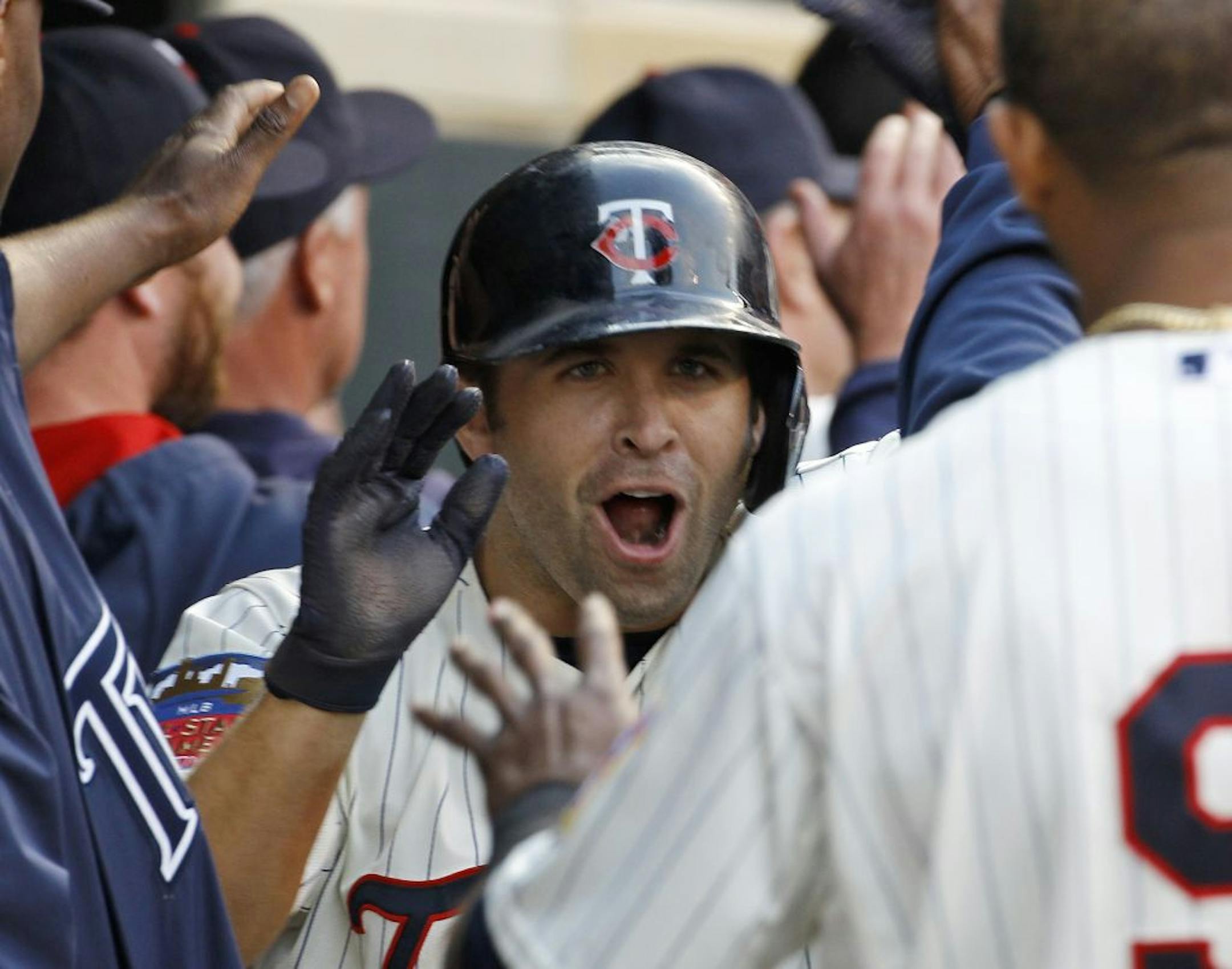 Minnesota Twins' Brian Dozier is congratulated in the dugout after hitting a three-run home run off Seattle Mariners starting pitcher Roenis Elias during the fifth inning of a baseball game in Minneapolis, Saturday, May 17, 2014. (AP Photo/Ann Heisenfelt) ORG XMIT: MIN2014051721014810