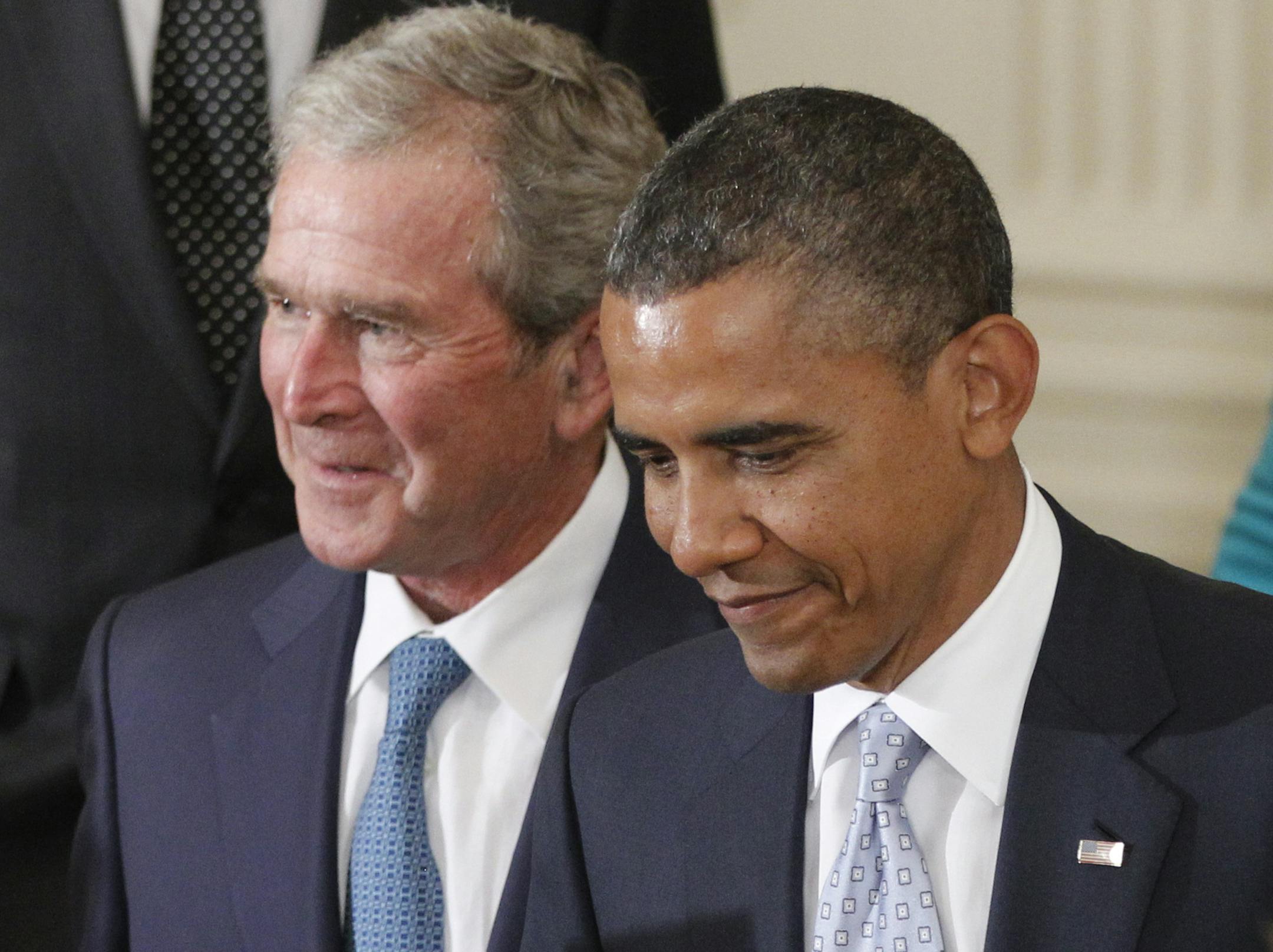President Barack Obama walks with former President George W. Bush during the unveiling of his official portraits in the East Room at the White House in Washington, Thursday, May 31, 2012. (AP Photo/Charles Dharapak)