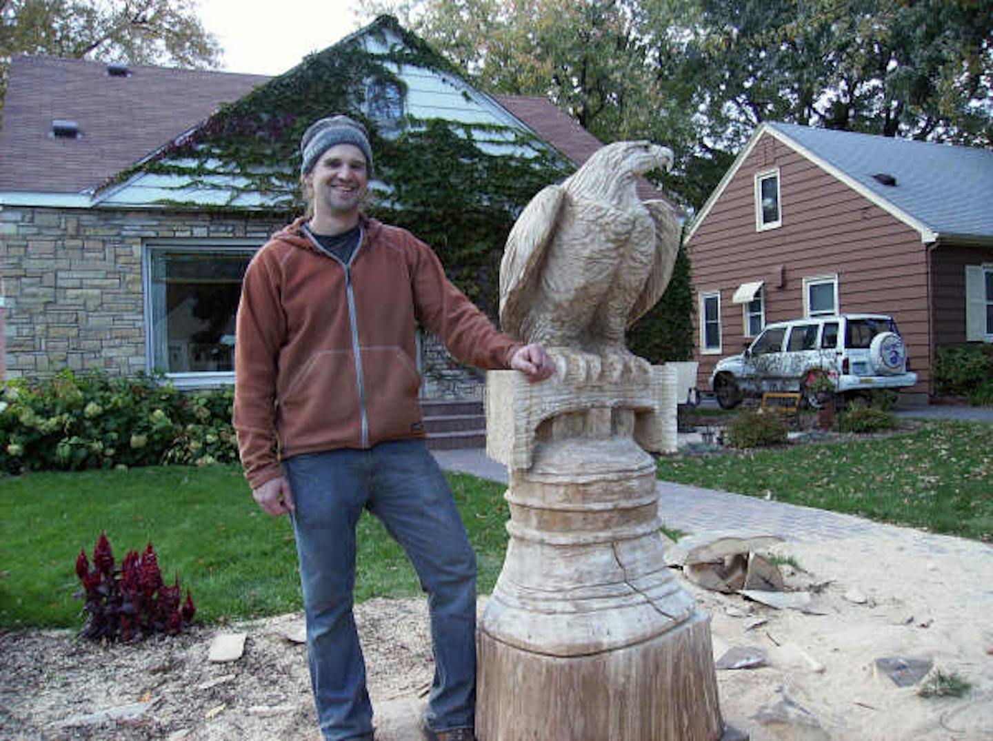 Credit should go to Mary Barnes. Wood sculptor Curtis Ingvoldstad with the eagle and Liberty Bell he carved out of the trunk of an elm tree felled by a storm at the Richfield home of John and Mary Barnes. 10/2008