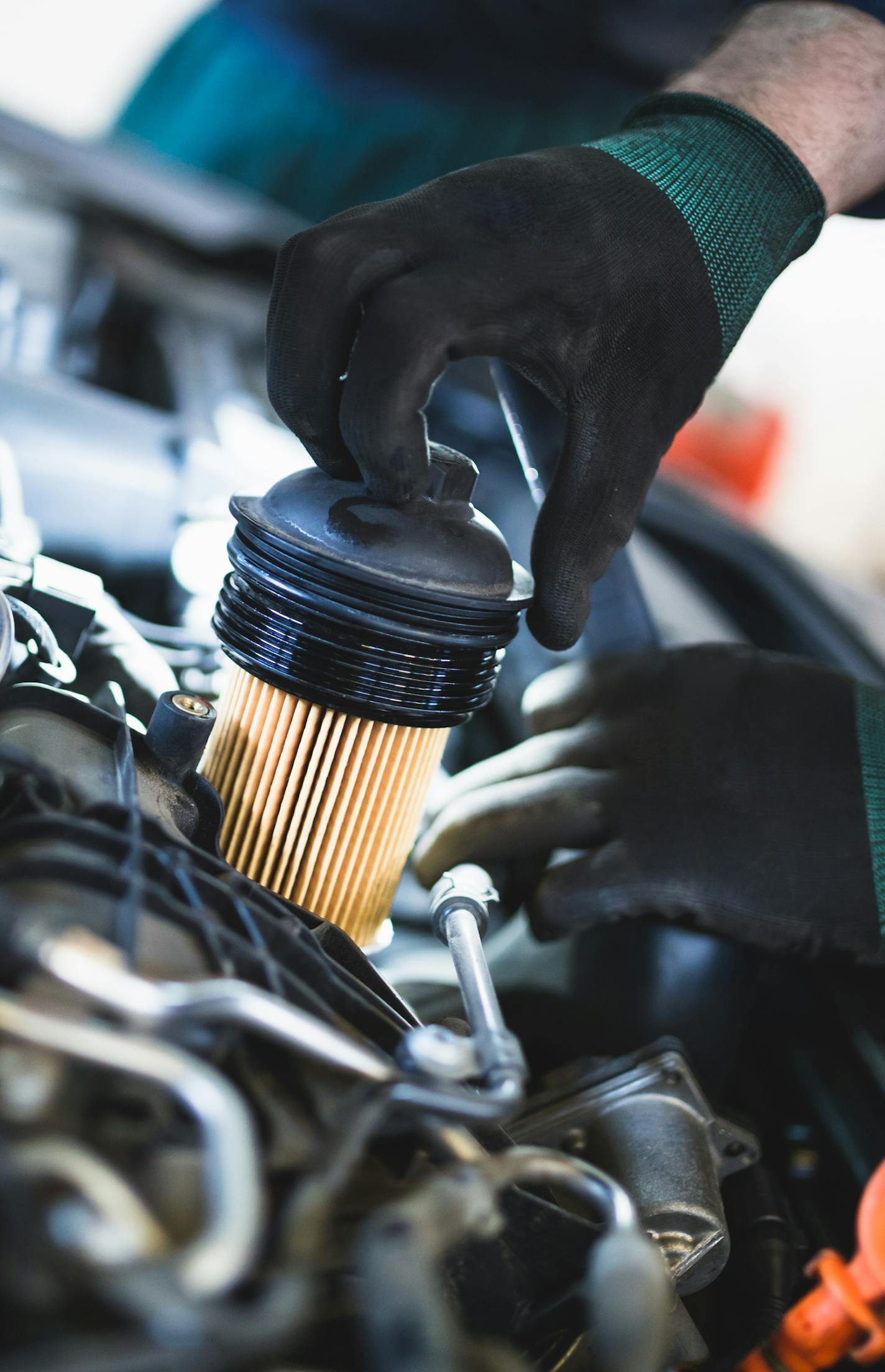 Close up hands of unrecognizable mechanic doing car service and maintenance. Oil and fuel filter changing.