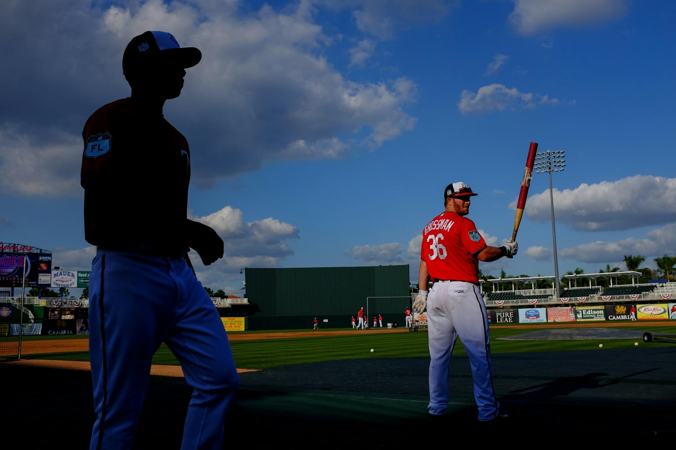 Minnesota Twins outfileder Robbie Grossman (36) warmed up his swing as second baseman Ehire Adrianza walked past during batting practice.