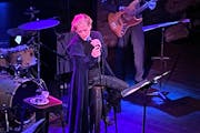 Shelby Lynne is sitting on a stool, clutching the microphone stand with two hands singing at the Dakota in downtown Minneapolis.