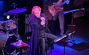 Shelby Lynne is sitting on a stool, clutching the microphone stand with two hands singing at the Dakota in downtown Minneapolis.