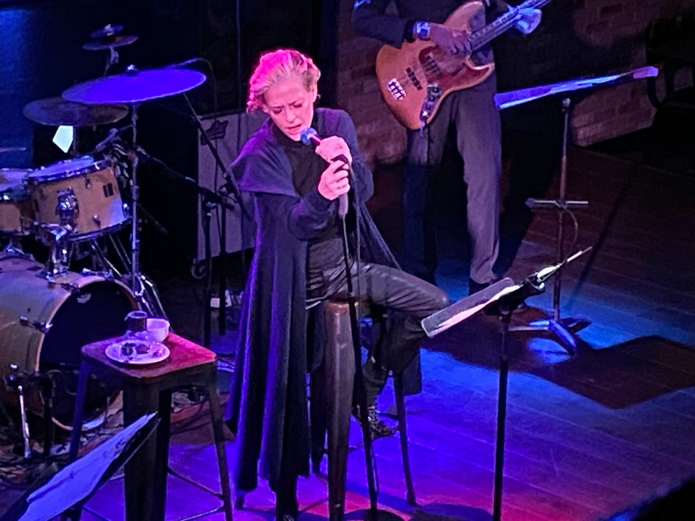 Shelby Lynne is sitting on a stool, clutching the microphone stand with two hands singing at the Dakota in downtown Minneapolis.