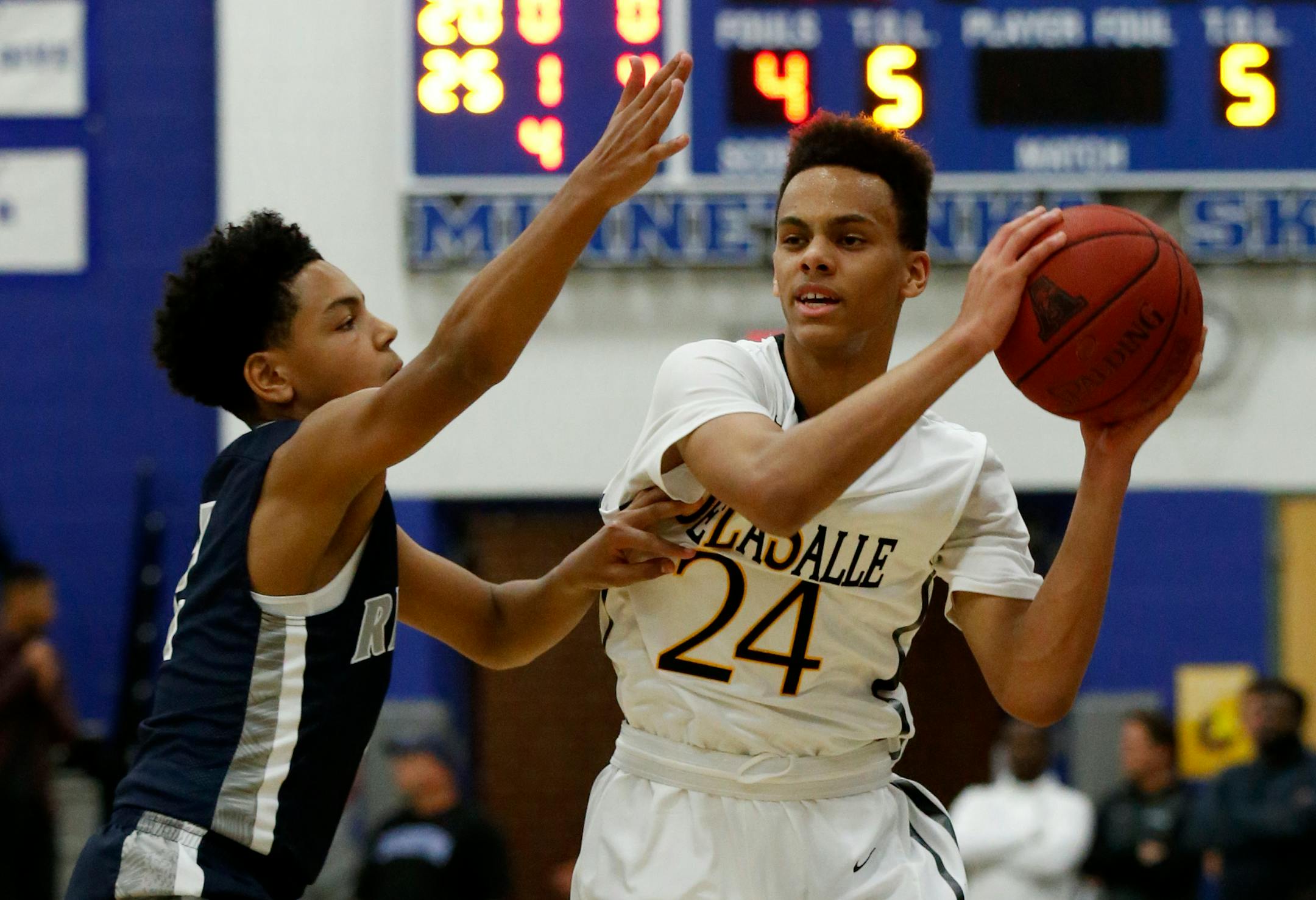 DeLaSalle guard Christian Dickson (24) looks to pass under pressure from Champlin Park guard Josiah Stron during the first half in Minnetonka, Saturday, Dec. 12, 2015. ( Photo/Ann Heisenfelt)